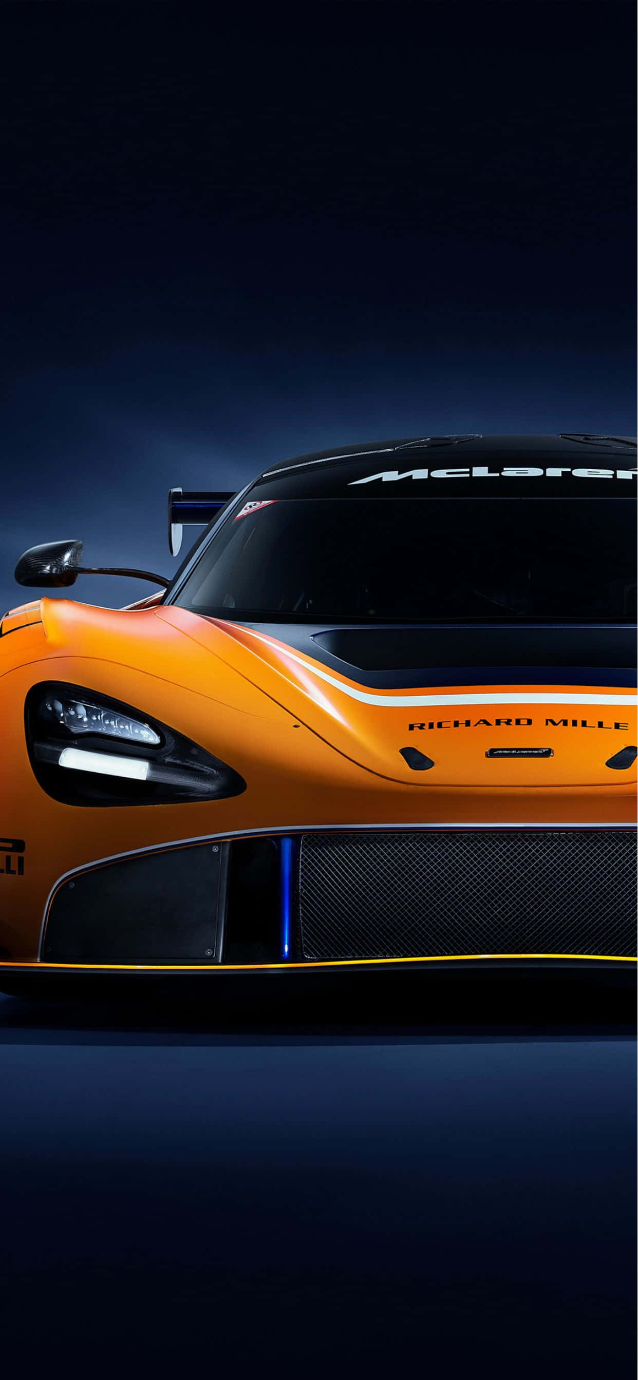 最快速、最奢華的觀景方式 壁紙 — 一輛時尚的橙色McLaren賽車，帶有黑色飾邊和藍色燈光，在黑暗背景下的戲劇性工作室燈光中閃耀。
