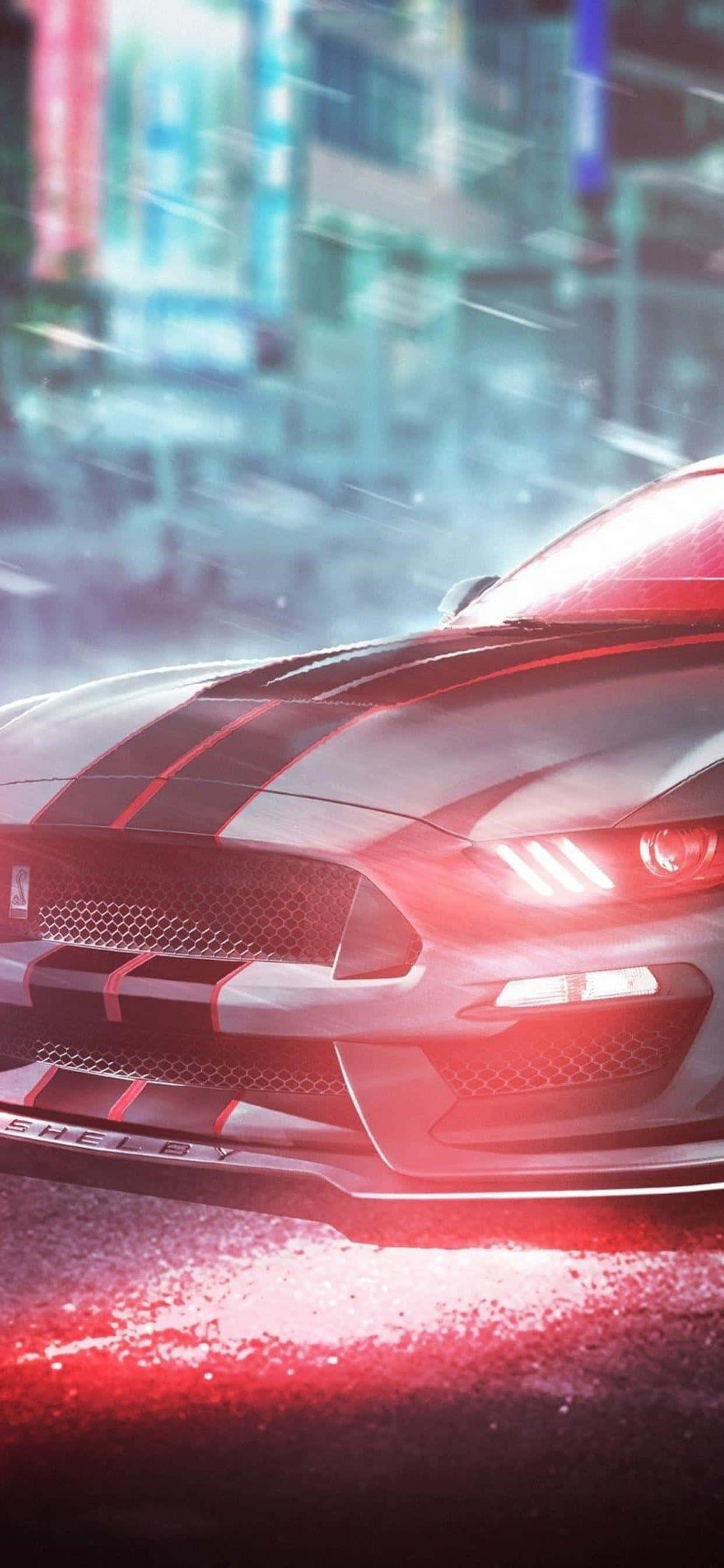 最新iPhone XS Max玩家體驗！ 壁紙 — 一架流線型紅色 Shelby Mustang GT500 在雨夜的霓虹燈城市街道上飛馳，車頭燈在濕漉漉的路面上反射出耀眼的光芒。