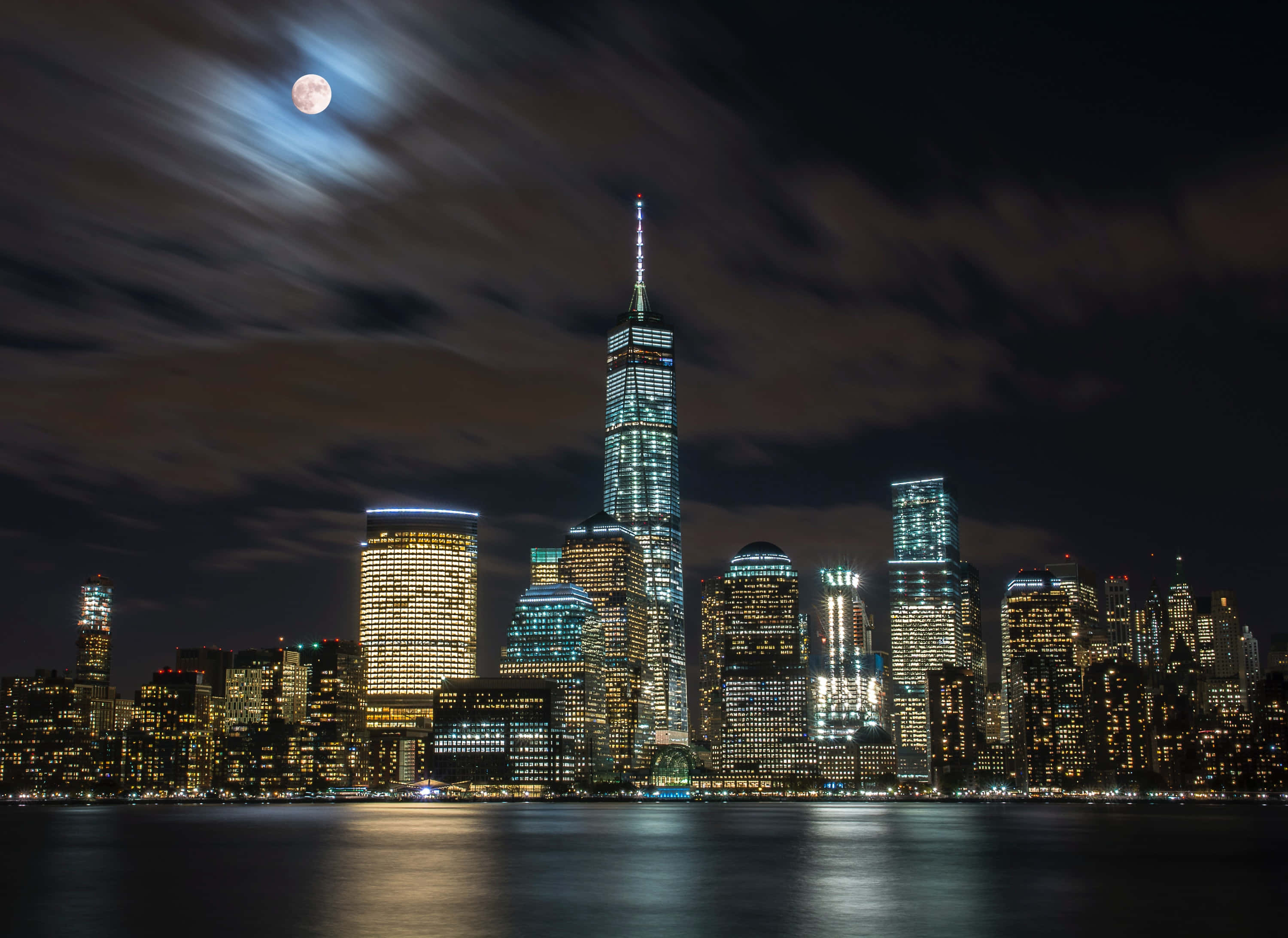 Nyc 桌布 壁紙 — 月光下的紐約市天際線夜景，明亮的摩天大樓倒映在水面上。