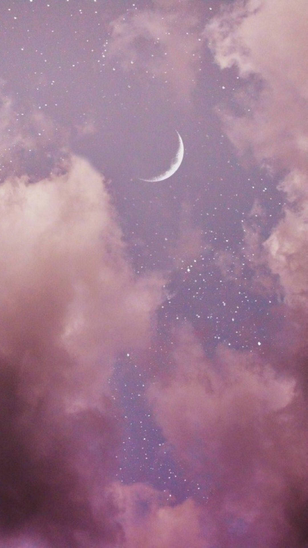 一彎新月在繁星點點的夜空中穿過粉紅雲朵閃耀。