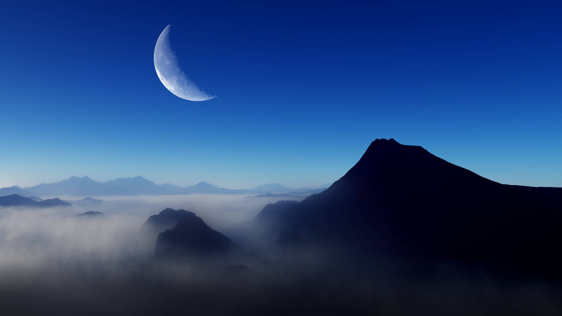 夜晚，月亮從霧雲中升起的山峰上方