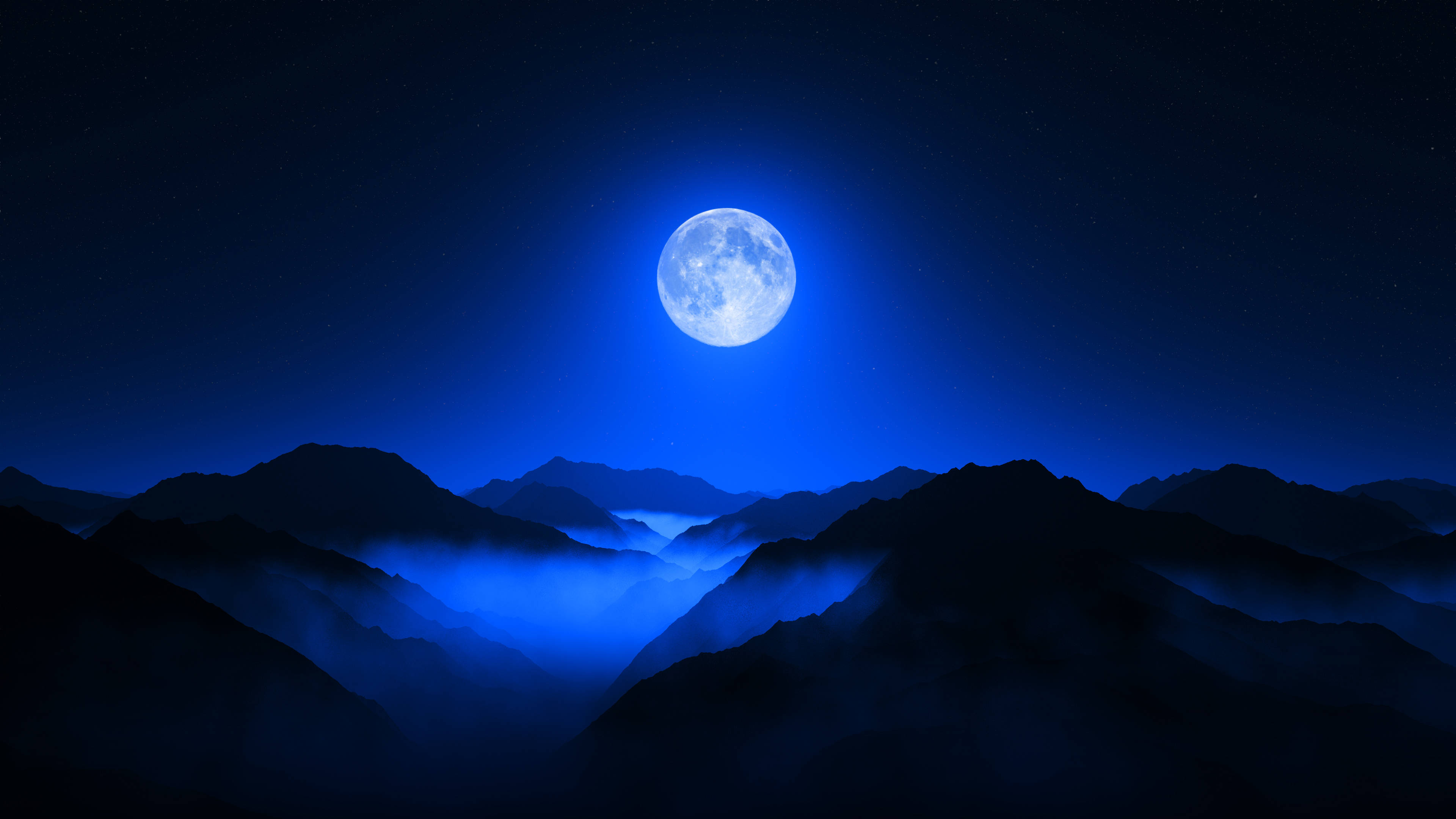 月光灑落山谷 壁紙 — 一輪明亮的滿月在繁星點點的夜空下，將冷藍色的光芒投射在籠罩於霧氣山谷中的剪影山峰上。