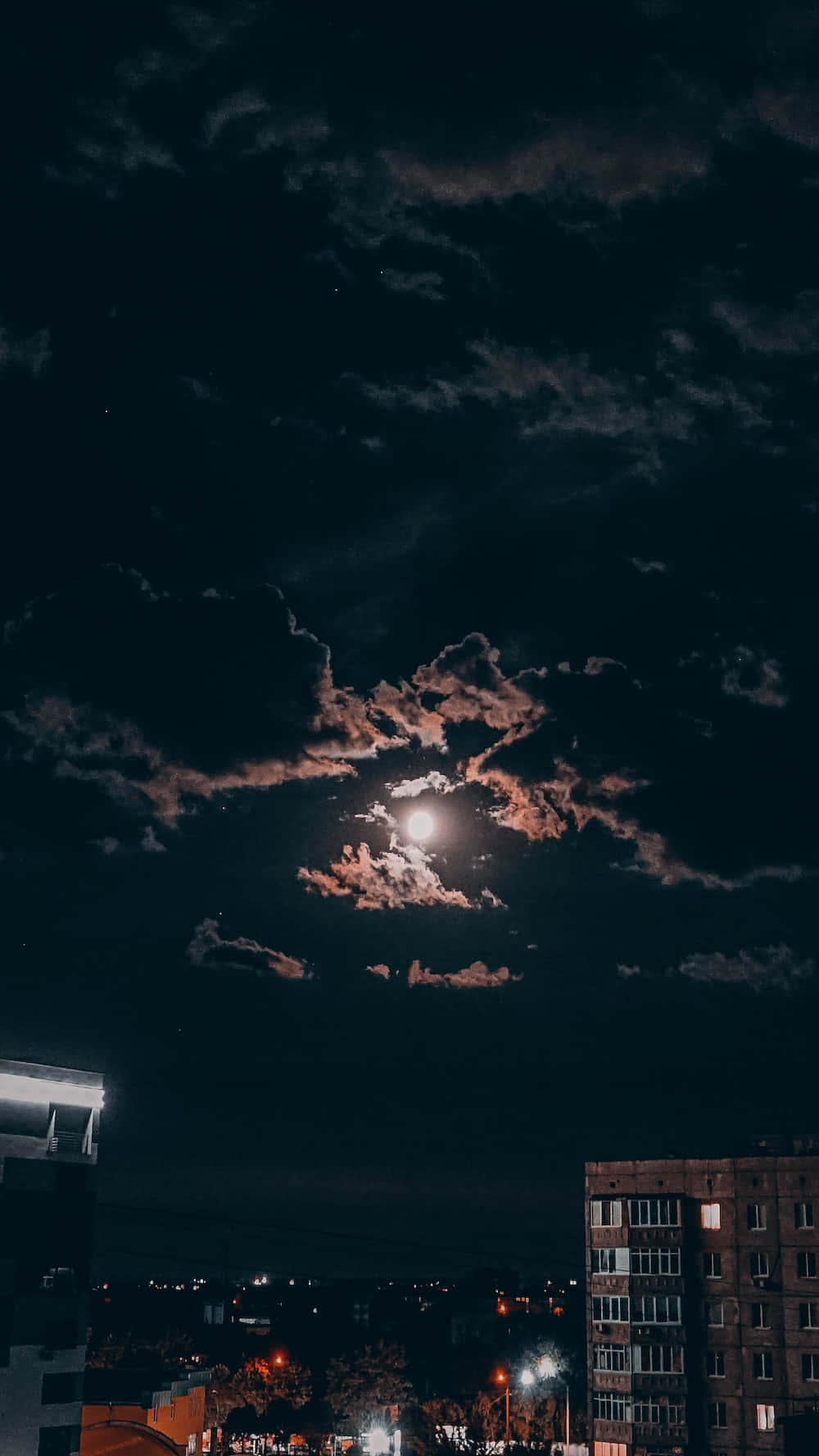 月光穿過雲層，灑落在夜晚的城市，街燈閃爍。