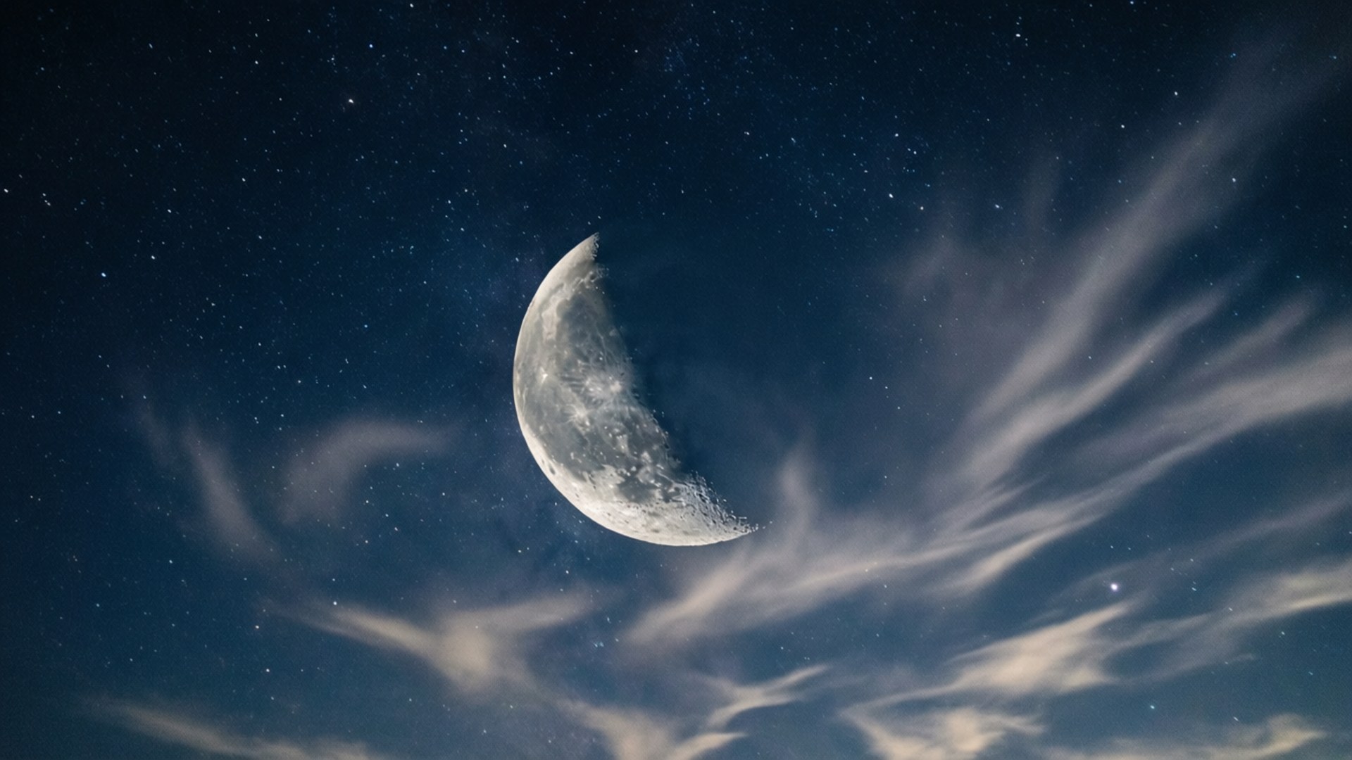 月光雲影 壁紙 — 一彎新月在繁星點點的夜空中閃耀，縷縷薄雲飄過。