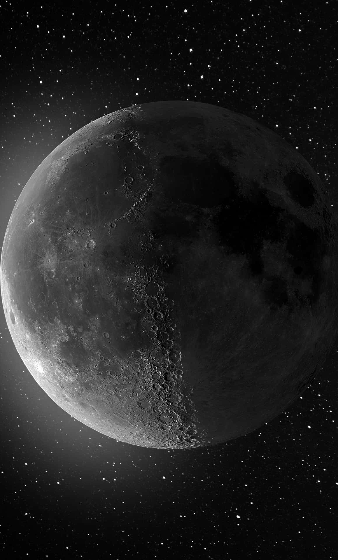 月球近照 iPhone 壁紙 — 月球佈滿隕石坑的表面在深空星場中發光的詳細灰階視圖。