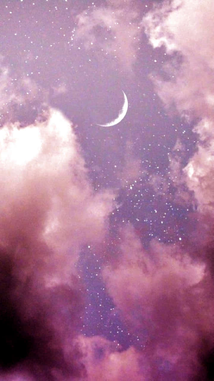 一彎新月在繁星點點的夜空下，穿過粉紅色的雲朵閃耀。