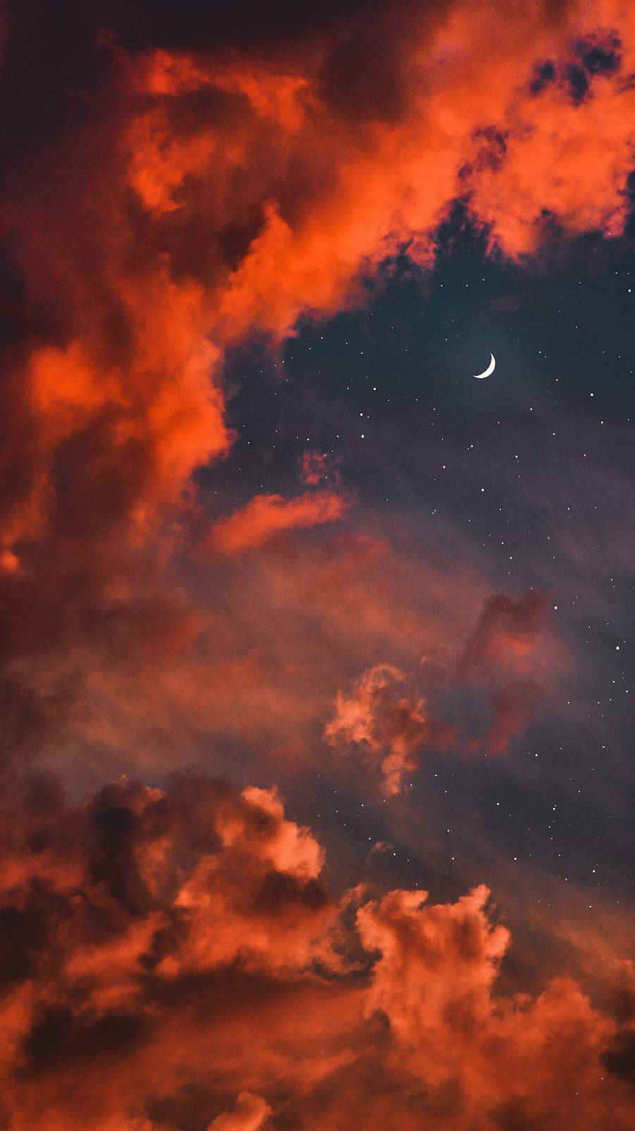 火紅的橙色雲朵在新月和閃爍的星星下飄移。