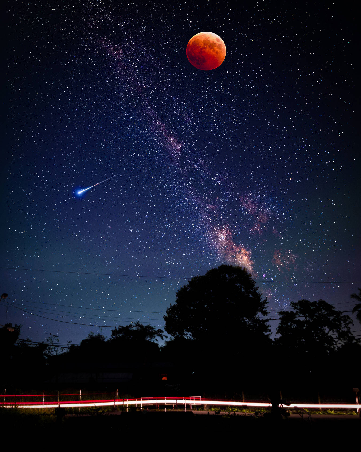血月同流星喺星空上，有樹木剪影同光跡。