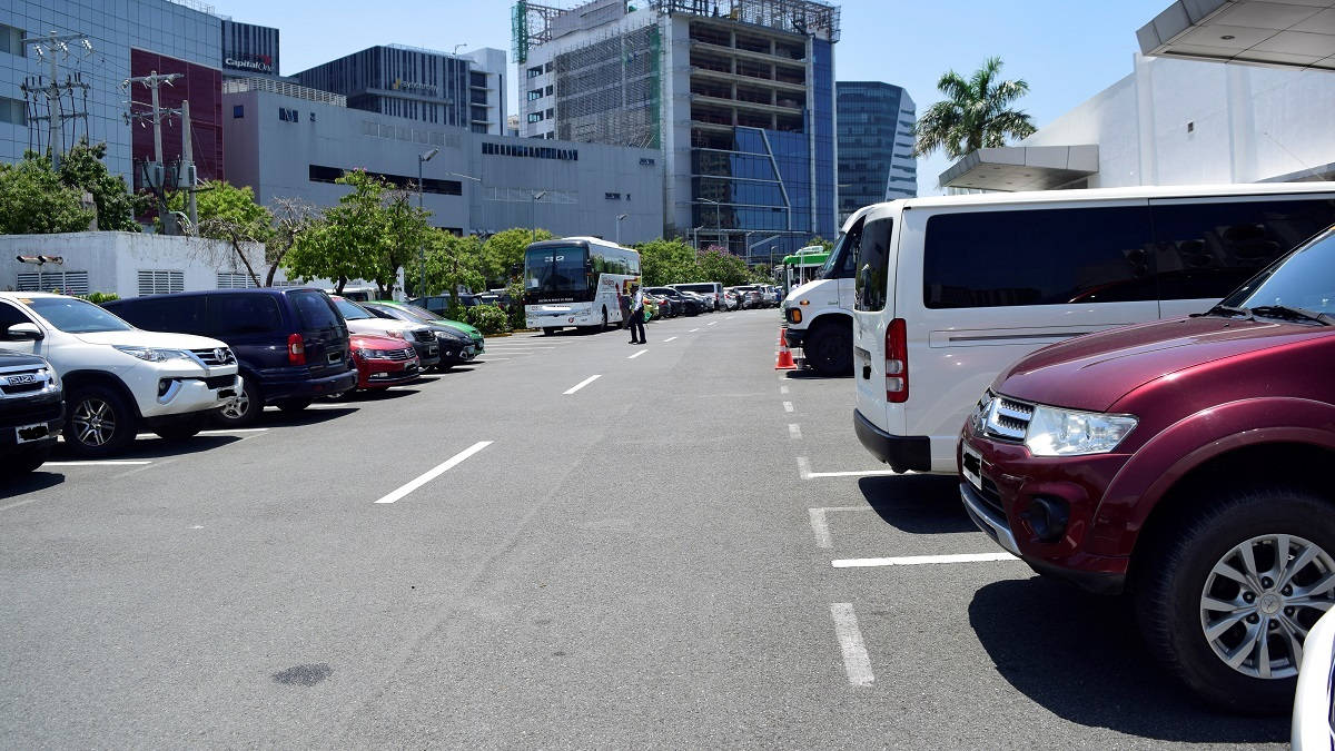 城市停車場，汽車和巴士在明亮的陽光下。