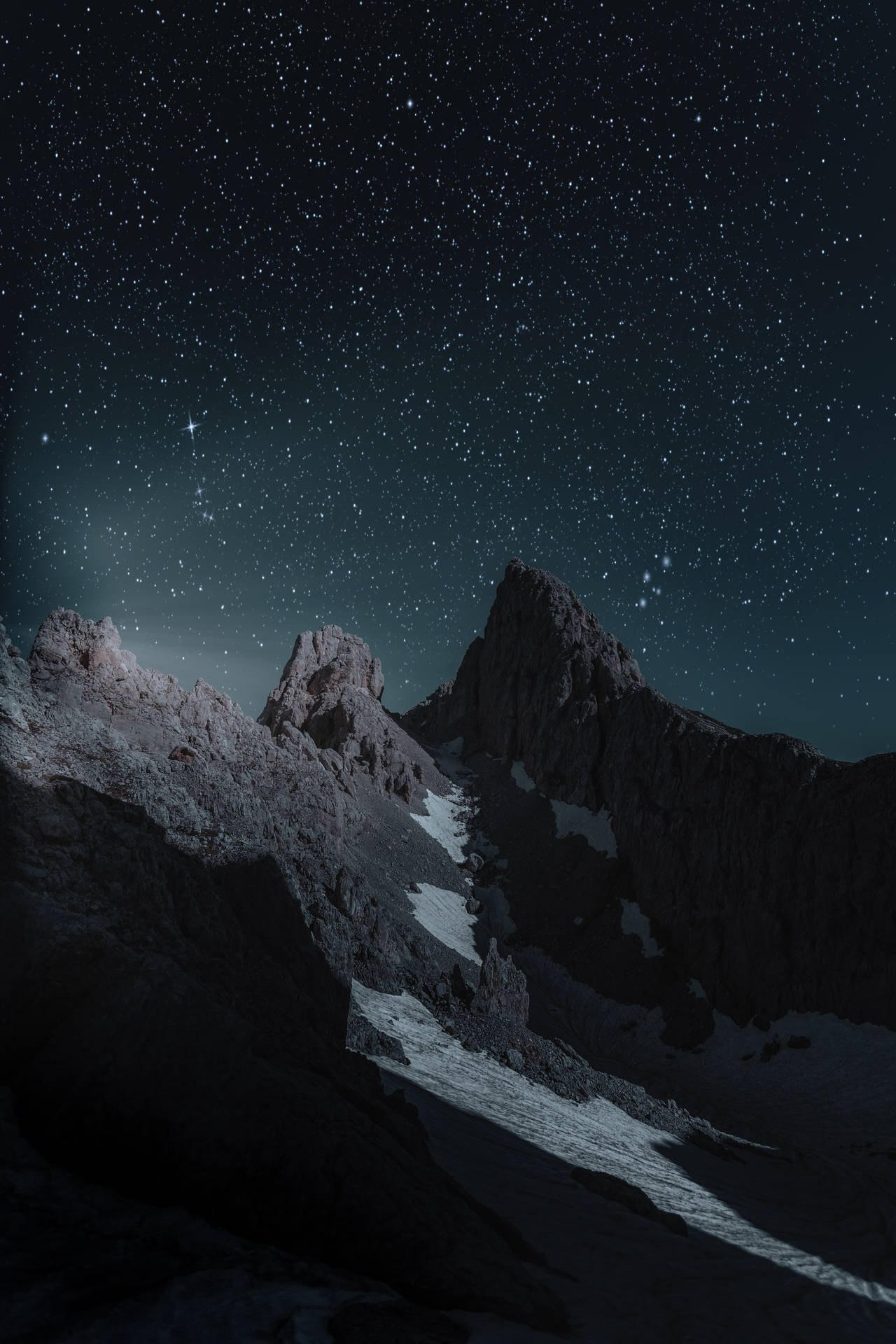 有趣夜色山巒iPhone背景 壁紙 — 深靛藍色的夜空下，繁星點點的夜空覆蓋著積雪覆蓋的鋸齒狀山峰。