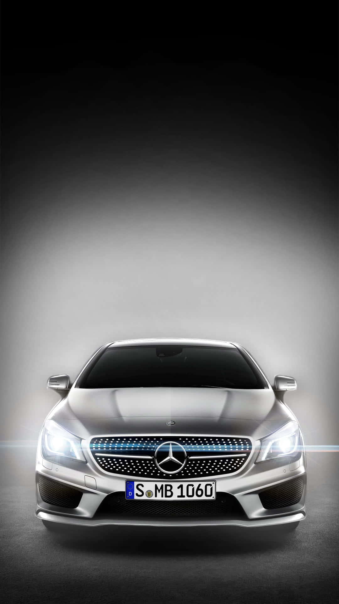 銀色 Mercedes-Benz CLA 的前視圖，頭燈亮起，格柵帶有藍色點綴。