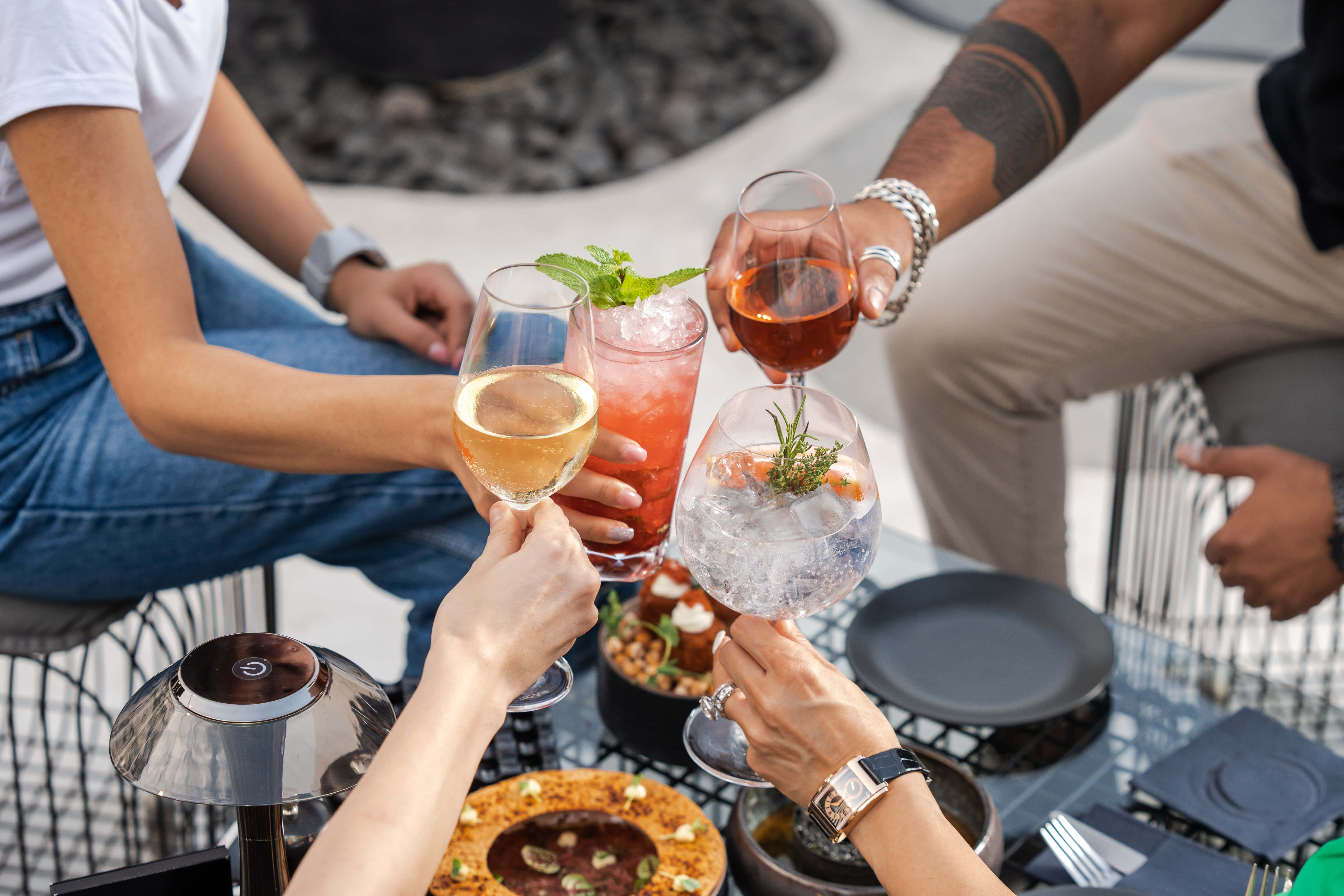 Summer Drinks 桌布 壁紙 — 朋友們在現代屋頂露台上，手持色彩繽紛的雞尾酒和小食碰杯。