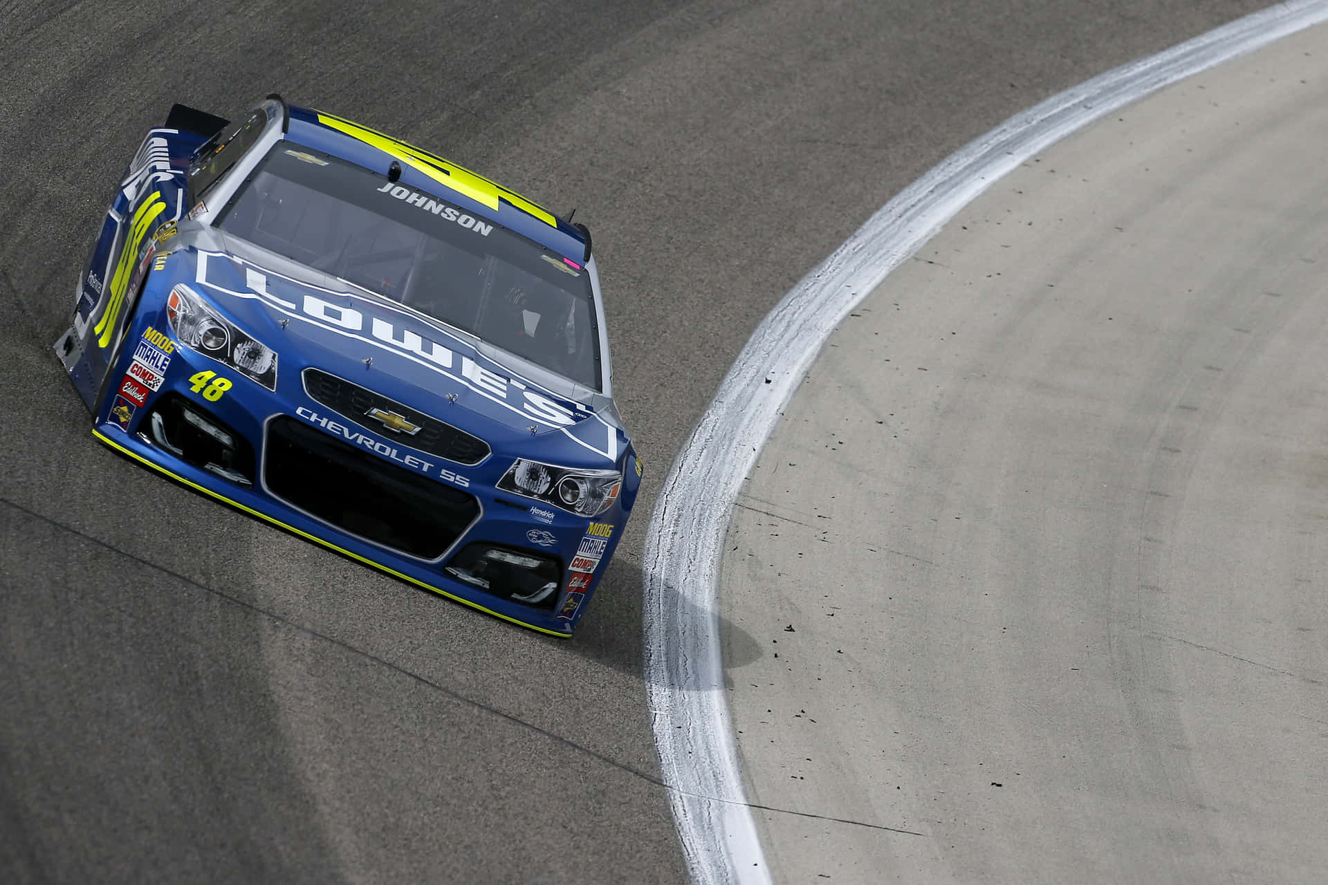 藍黃色NASCAR賽車編號48在賽道上過彎。