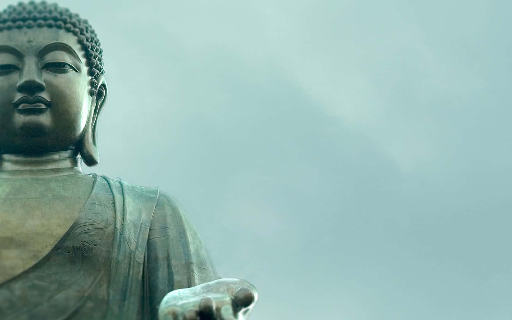 寧靜的青銅佛像，眼神平靜，手伸出，背景是朦朧的天空。