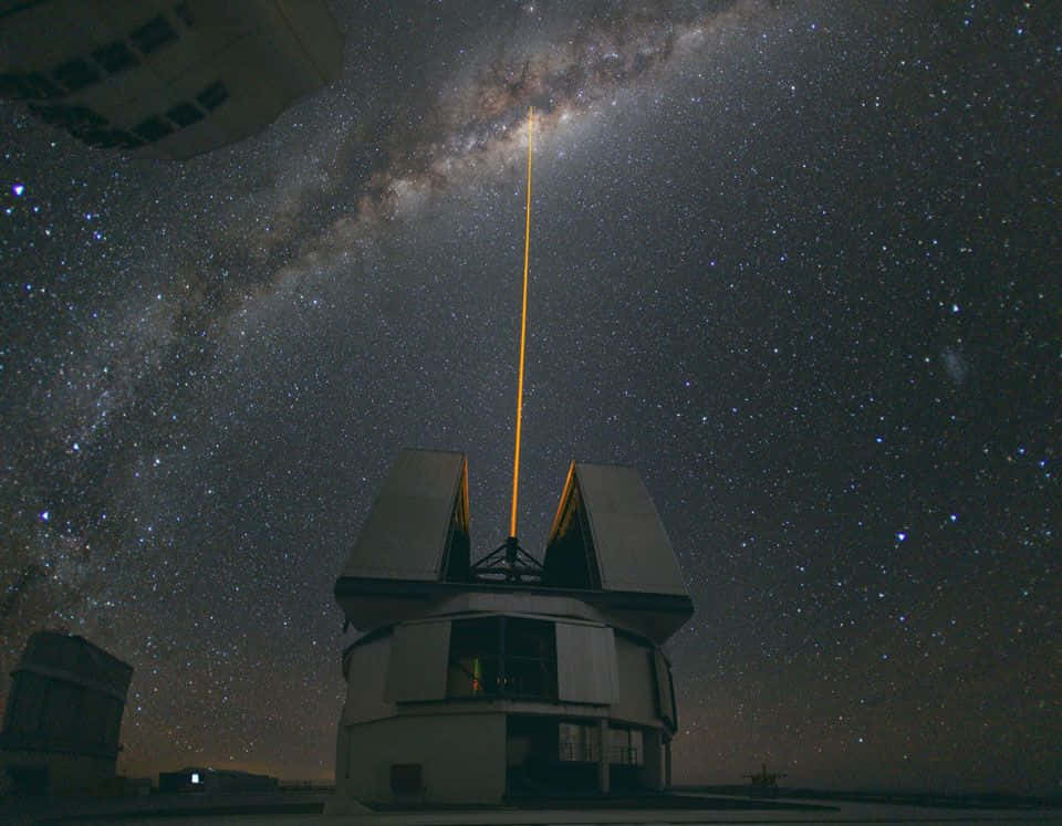 Galactic Center 桌布 壁紙 — 望遠鏡天文台在繁星點點的夜空下，向銀河系發射一道明亮的激光。