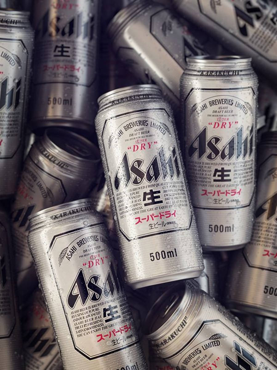 朝日超乾啤酒日本釀造 壁紙 — 冷藏嘅Asahi Super Dry啤酒罐堆埋一齊，銀色表面上有冷凝水珠閃閃發光嘅特寫。