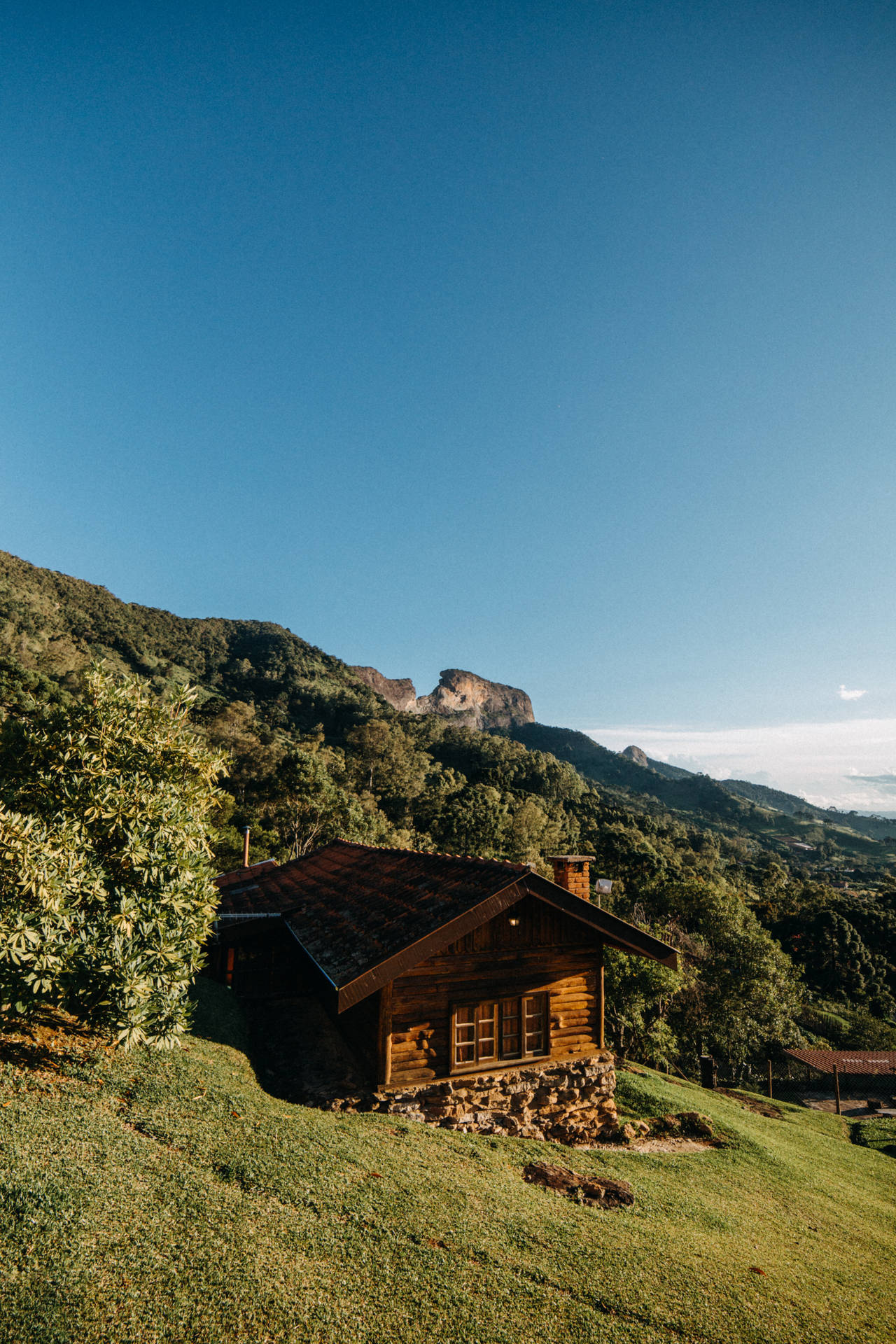 草地上的質樸木屋，青山和藍天