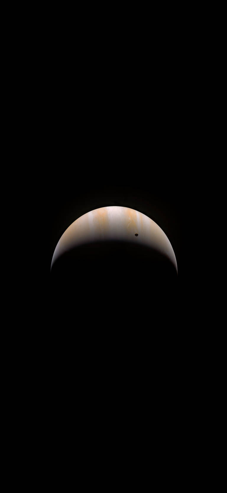 木星處於新月相位，一顆小衛星在太空的黑色虛空中可見。