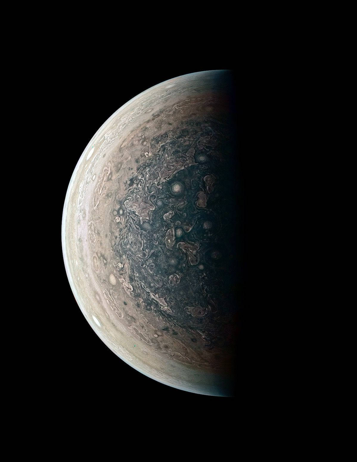 木星嘅旋轉風暴同大紅斑喺太空嘅黑暗中照亮。