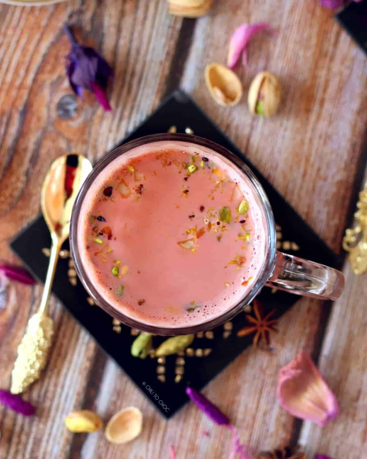 Pink Tea 桌布 壁紙 — 木桌上粉紅色牛奶飲品的俯視圖，飾以開心果和香料。