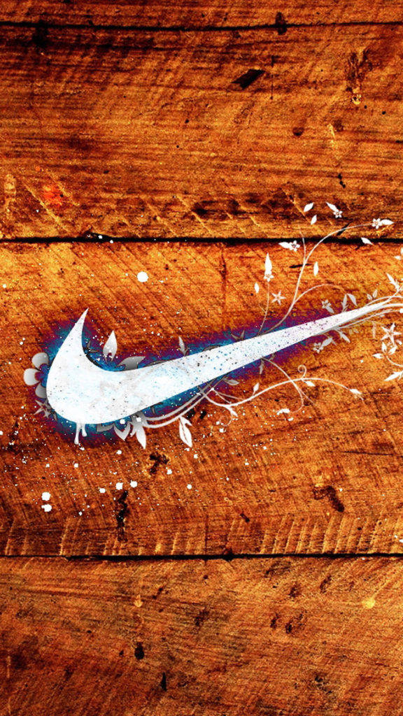 木紋Nike iPhone壁紙 壁紙 — 一個白色Nike剔號帶有花卉噴濺圖案，放置在帶有溫暖棕色調的風化木質表面上。
