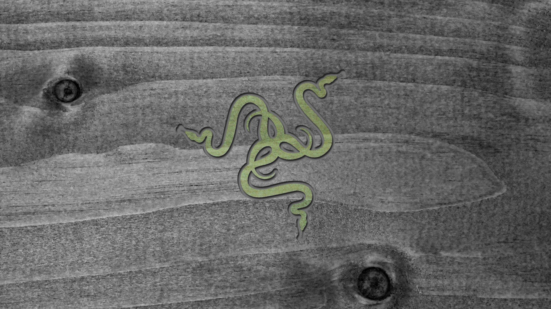 木紋背景的 Razer PC 標誌 壁紙 — 一個綠色的 Razer 標誌蜿蜒穿過風化的灰色木紋，帶有可見的節疤和紋理。