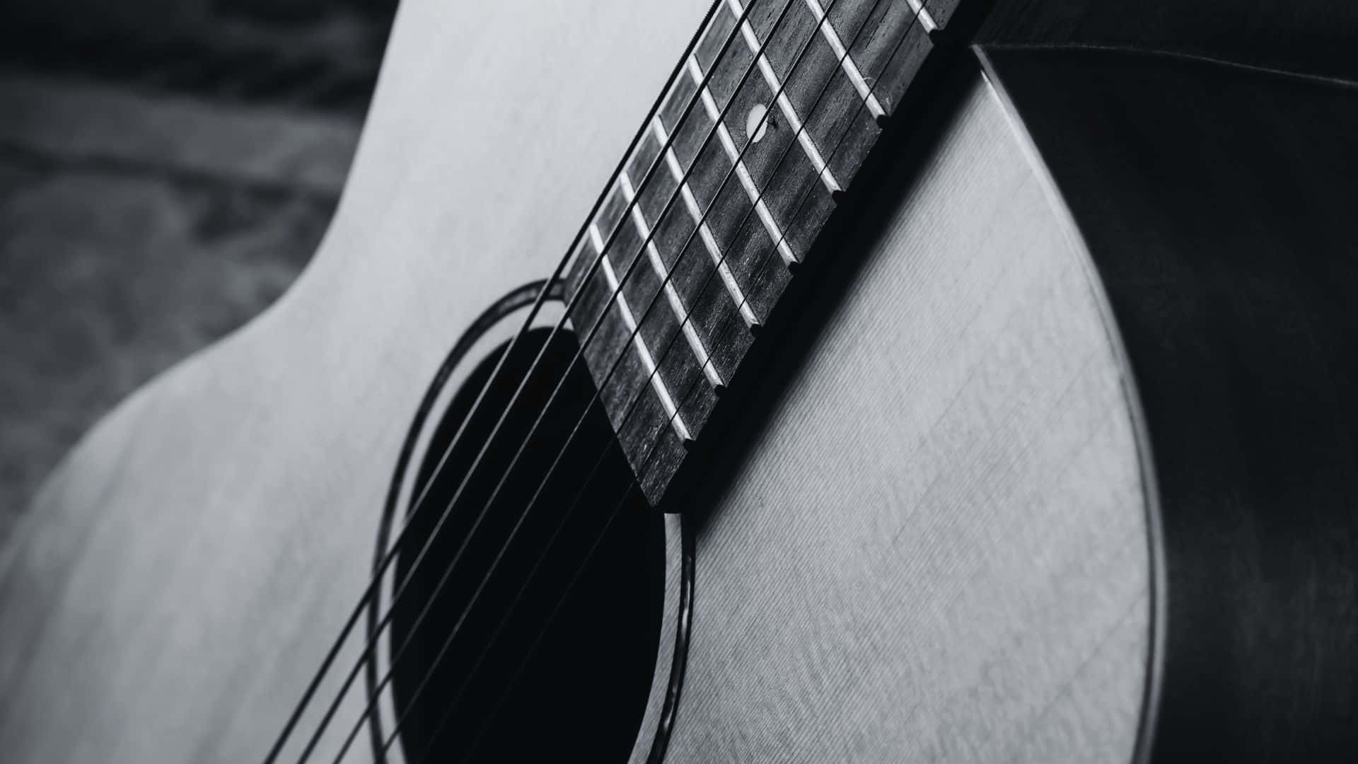 Black And White Guitar 桌布 壁紙 — 木結他琴身及指板的單色特寫，清晰聚焦於木紋和琴弦。