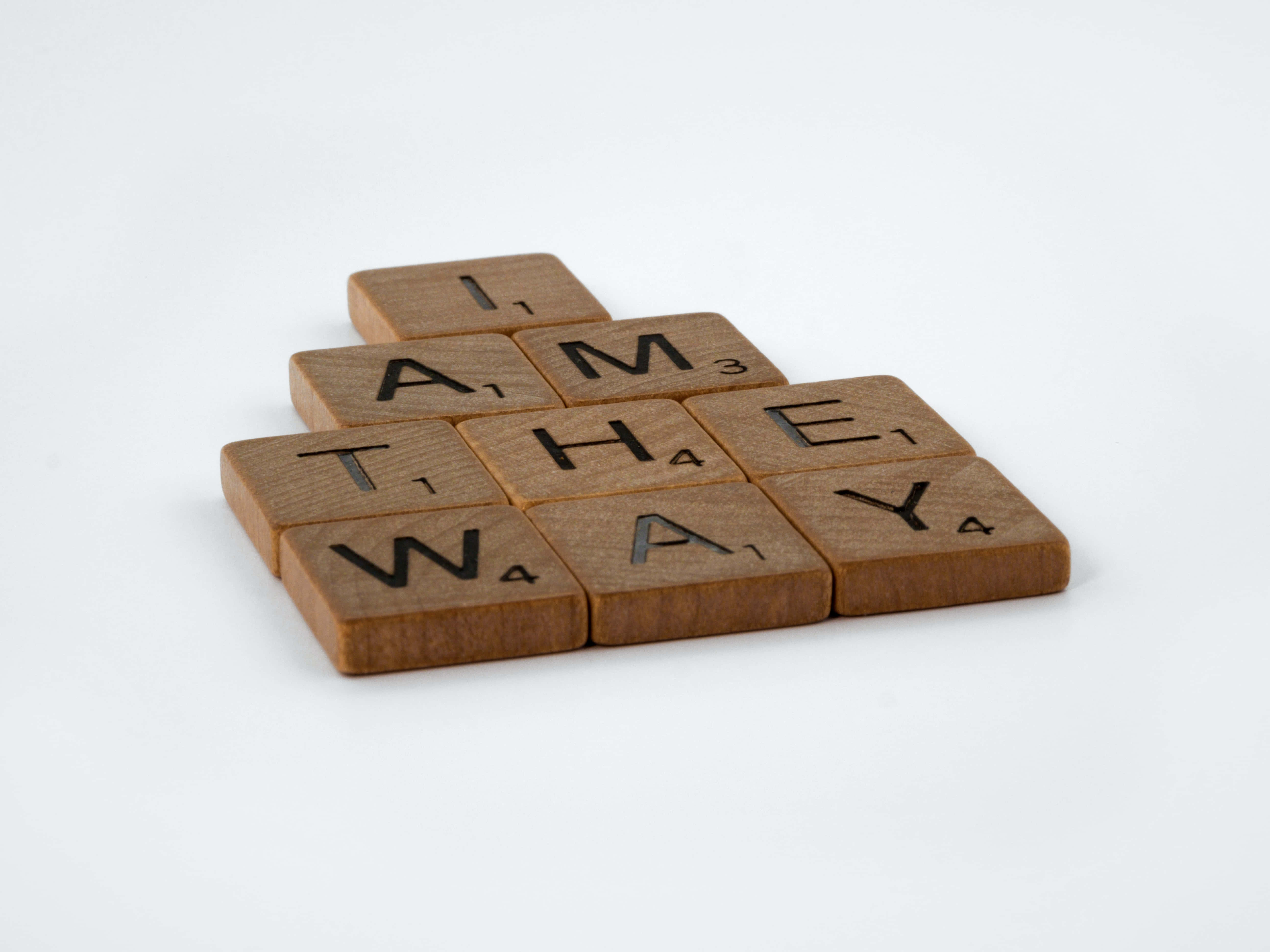 Gospel 桌布 壁紙 — 木製 Scrabble 字母牌拼出 'I AM THE WAY'，以金字塔形排列在白色背景上。