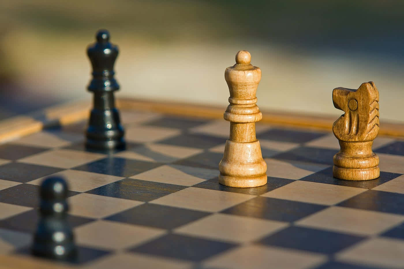Chessboard 桌布 壁紙 — 木製國際象棋棋子喺格仔棋盤上嘅特寫，柔和陽光投射出陰影。