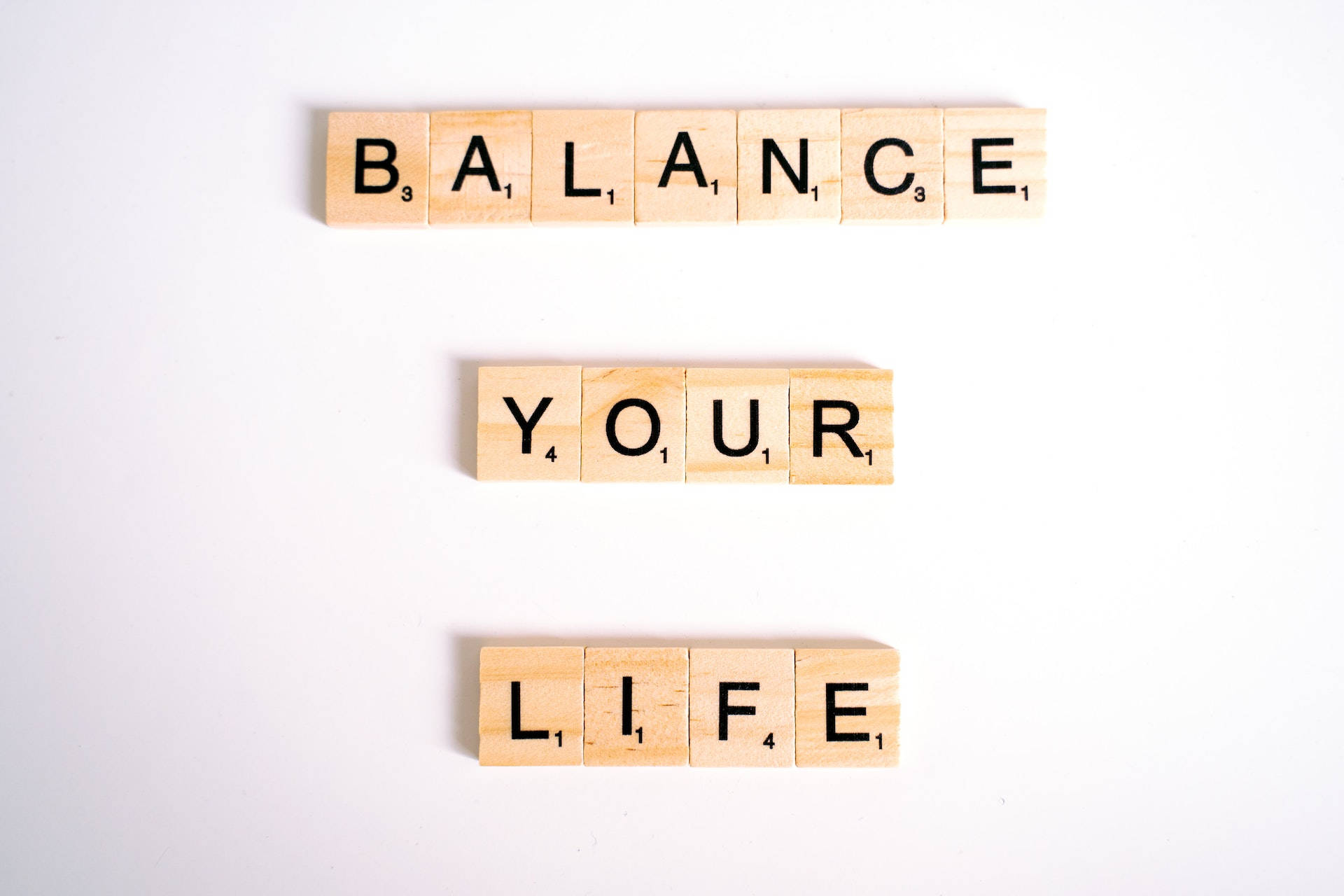 木製 Scrabble 字母牌在白色背景上拼出 balance your life