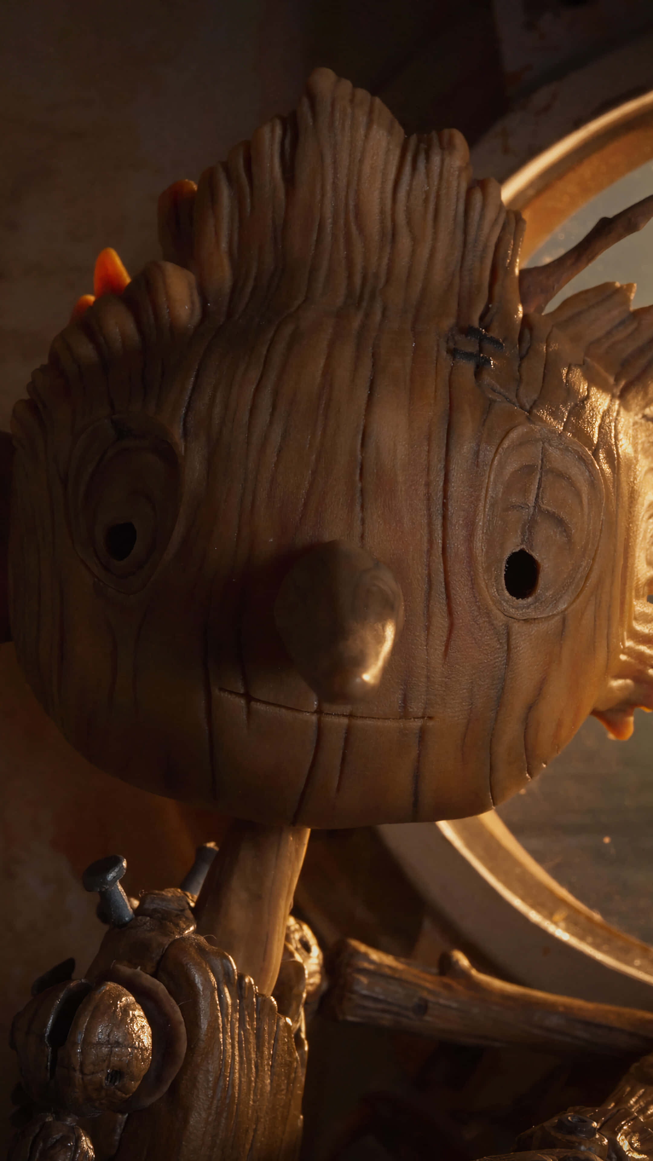 Guillermo Del Toro's Pinocchio 桌布 壁紙 — 木製格魯特公仔嘅特寫，具有紋理樹皮狀皮膚同溫暖燈光，突顯其雕刻嘅面部特徵。