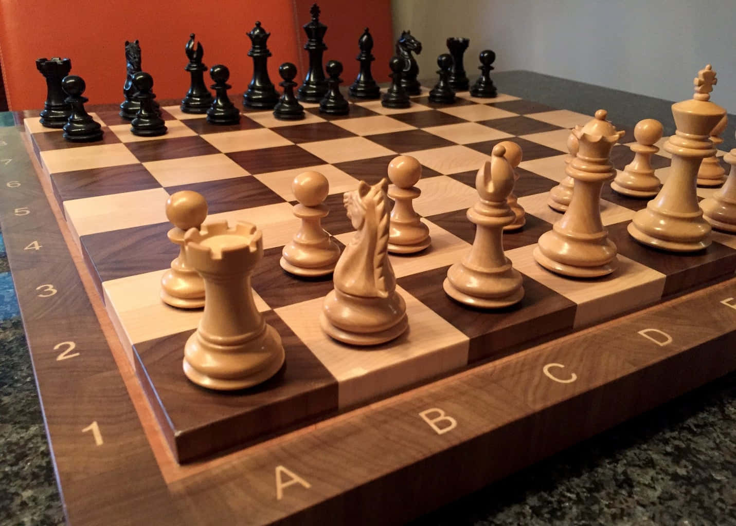 Chessboard 桌布 壁紙 — 木製棋盤的特寫，上面有淺色和深色棋子，排列在枱面上準備對弈。
