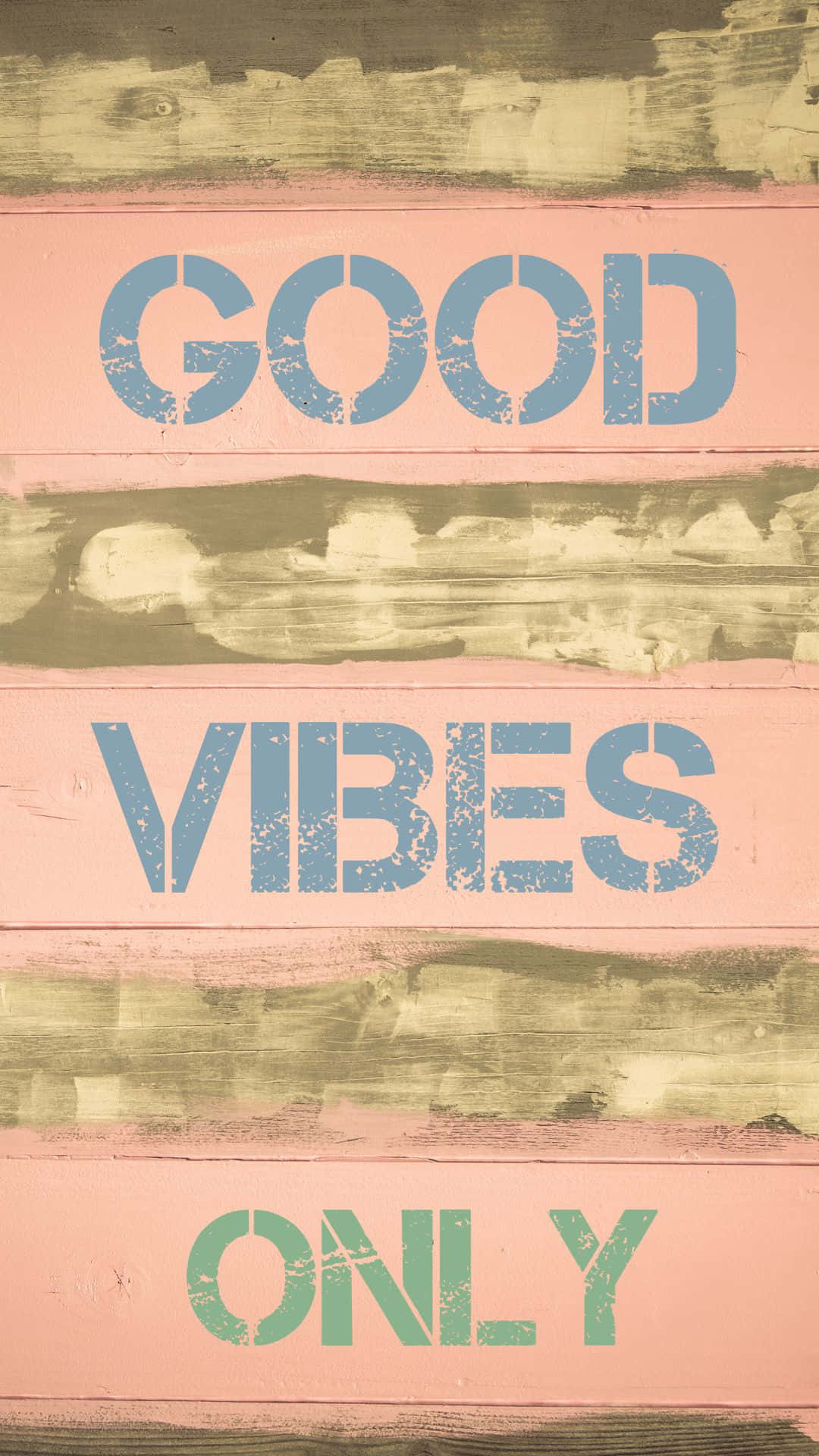 風化木牌上以藍色和綠色的模板文字寫著 good vibes only。