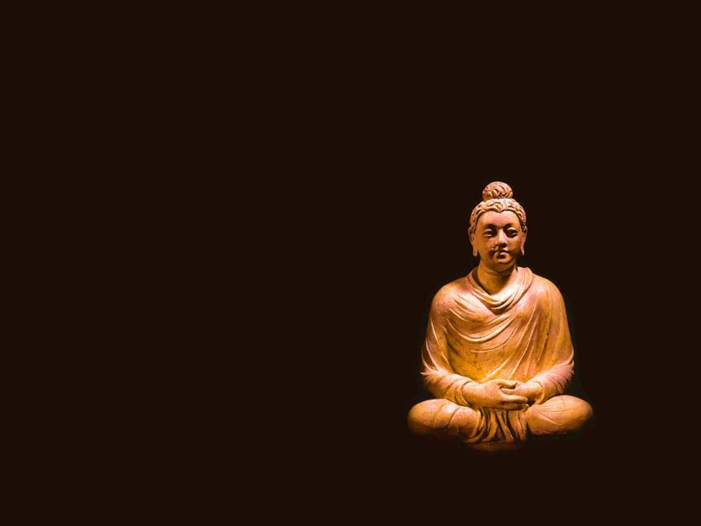 木製佛像在黑暗中以柔和光線冥想。