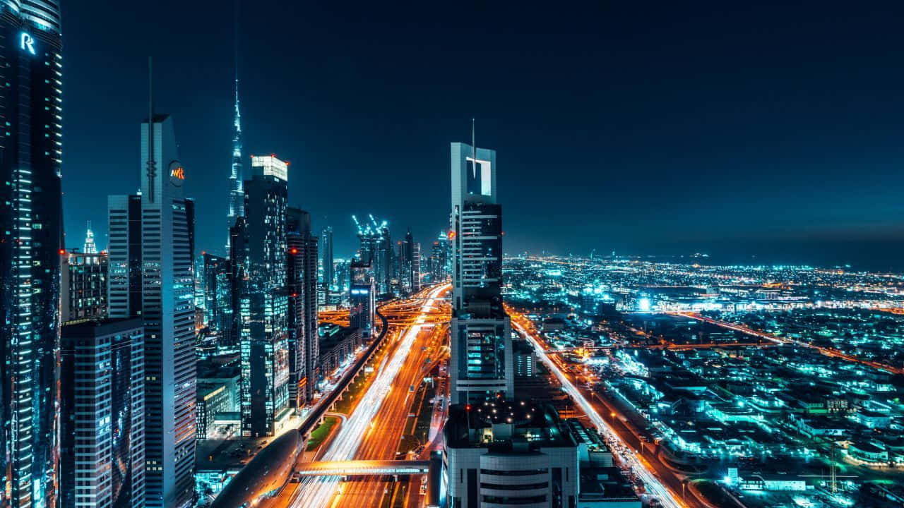 Dubai 桌布 壁紙 — 未來城市景觀的空中夜景，閃爍的摩天大樓和流動的交通燈光。