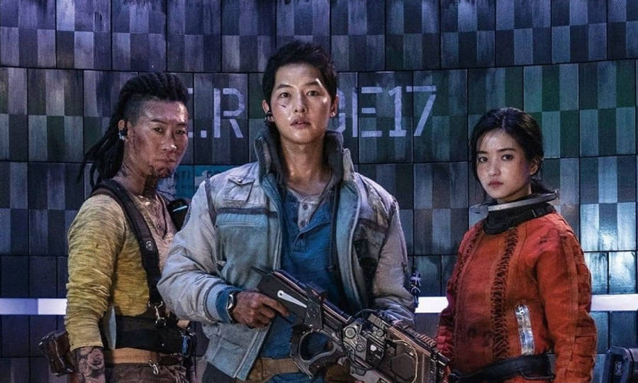 未來太空船清理太空垃圾 壁紙 — 三名粗獷的未來戰士手持武器，站在一面顯示 'R.E.17' 的格仔牆前準備就緒。