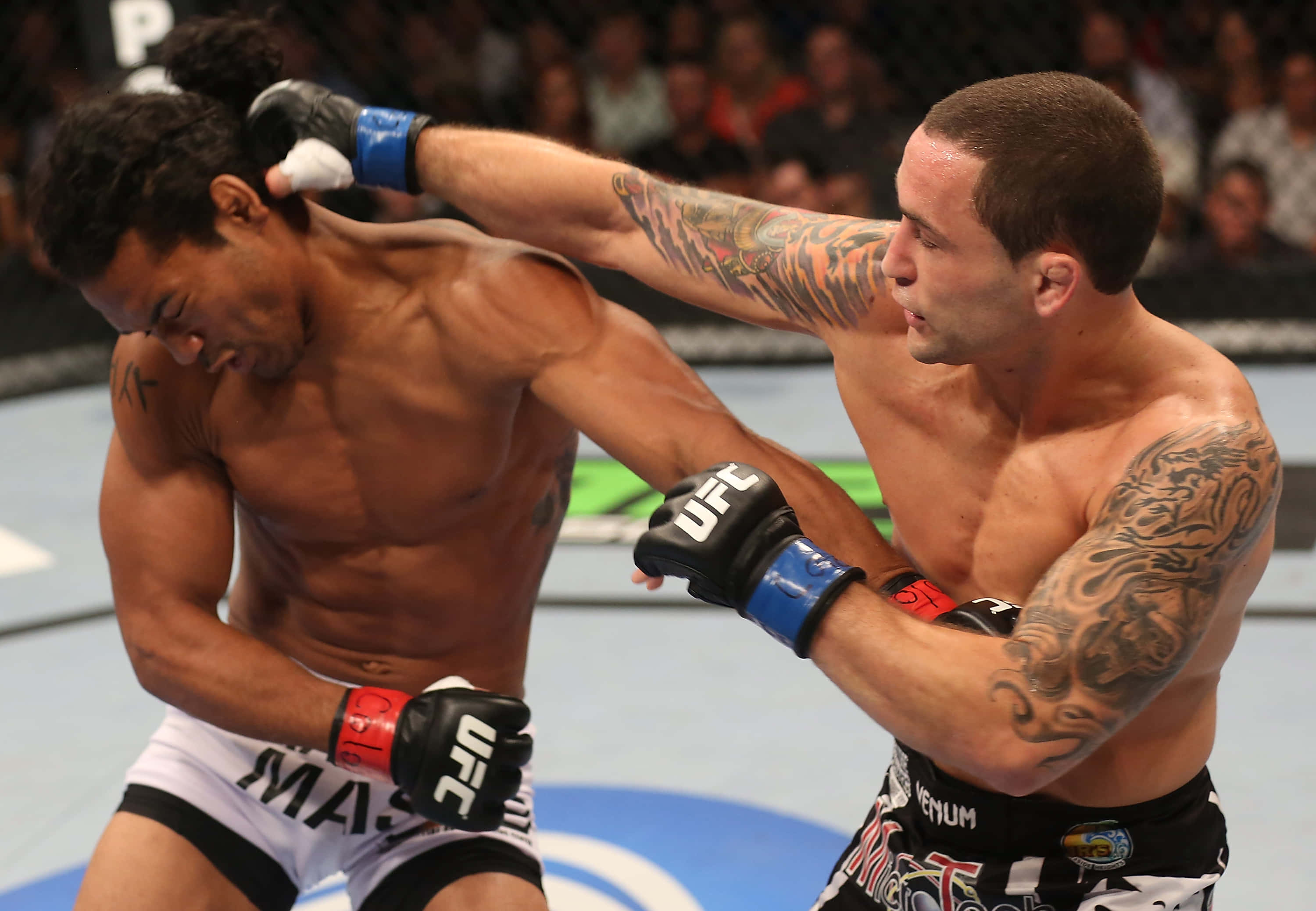 本·亨德森與弗蘭基·愛德加 UFC 150 壁紙 — 兩名肌肉發達的MMA拳手在激烈的UFC比賽中交鋒，其中一人打出強力一拳。