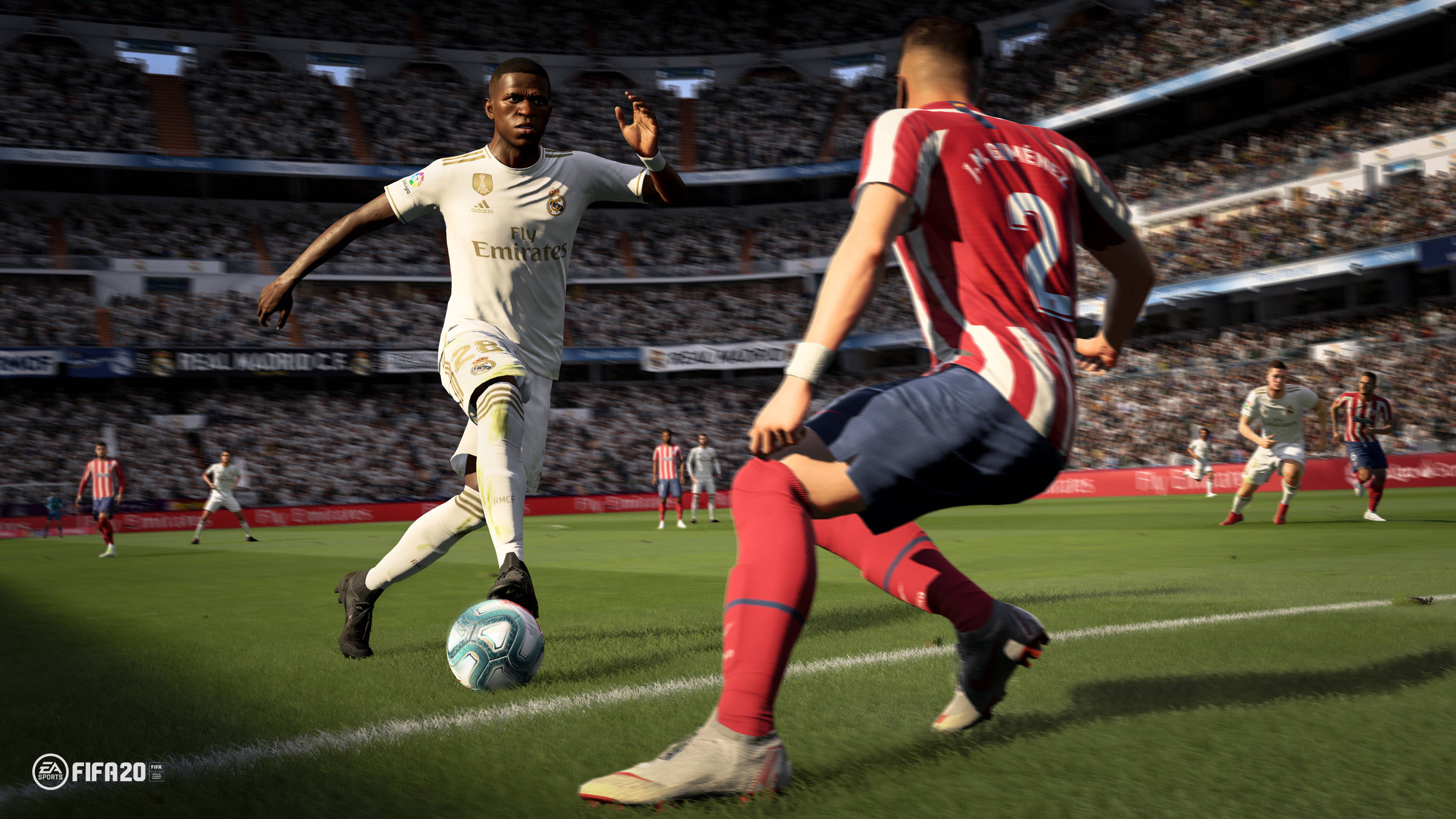 本傑明·門迪白色金屬阿聯酋球衣 壁紙 — 一名身穿白色球衣的足球員在擠滿觀眾的球場比賽中，盤球越過身穿紅白間條球衣的後衛。