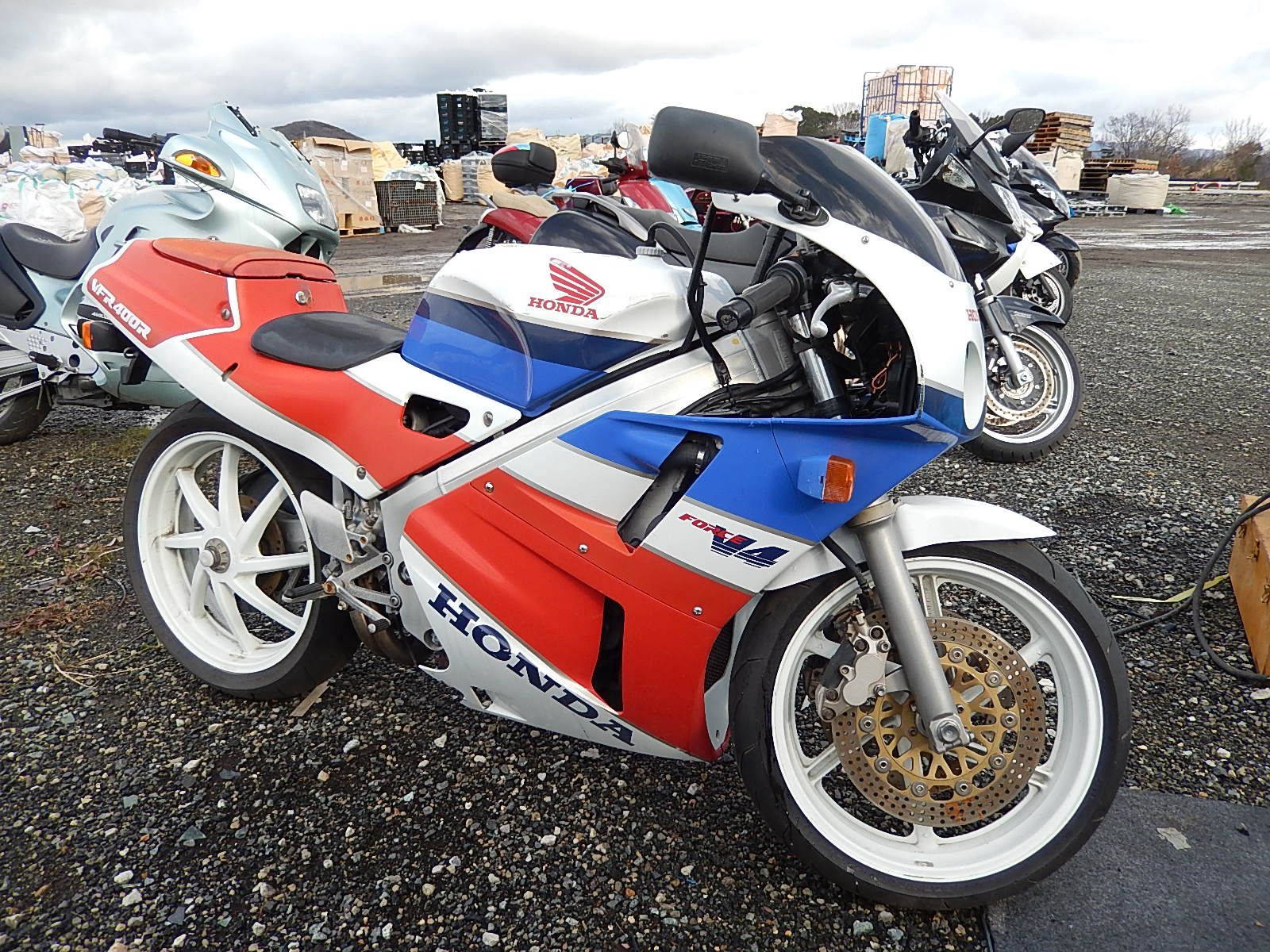 紅色、白色和藍色的本田CBR1100XX運動電單車停泊在廢車場。