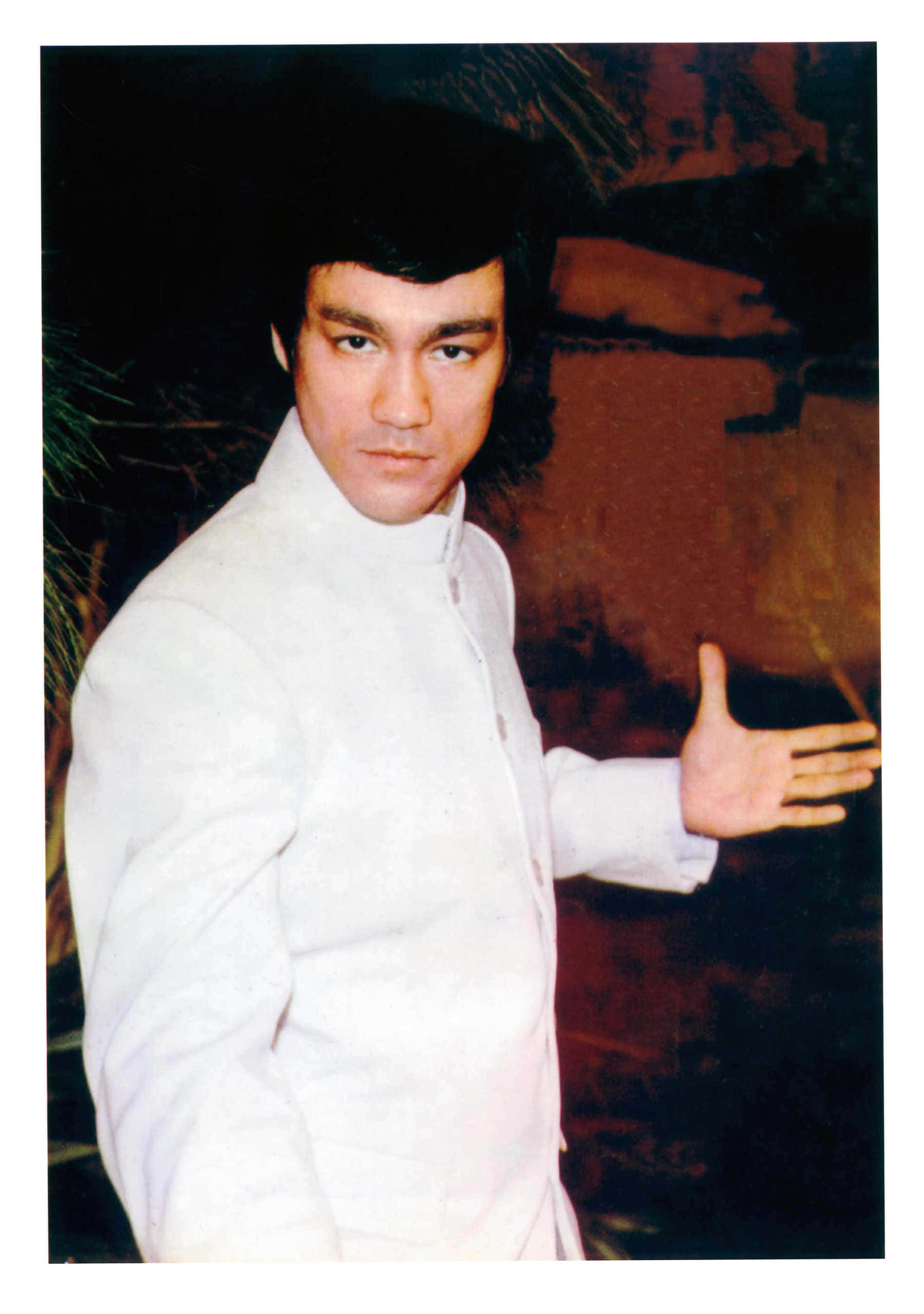 李小龍身穿白色武術服，擺出冷靜的姿勢。