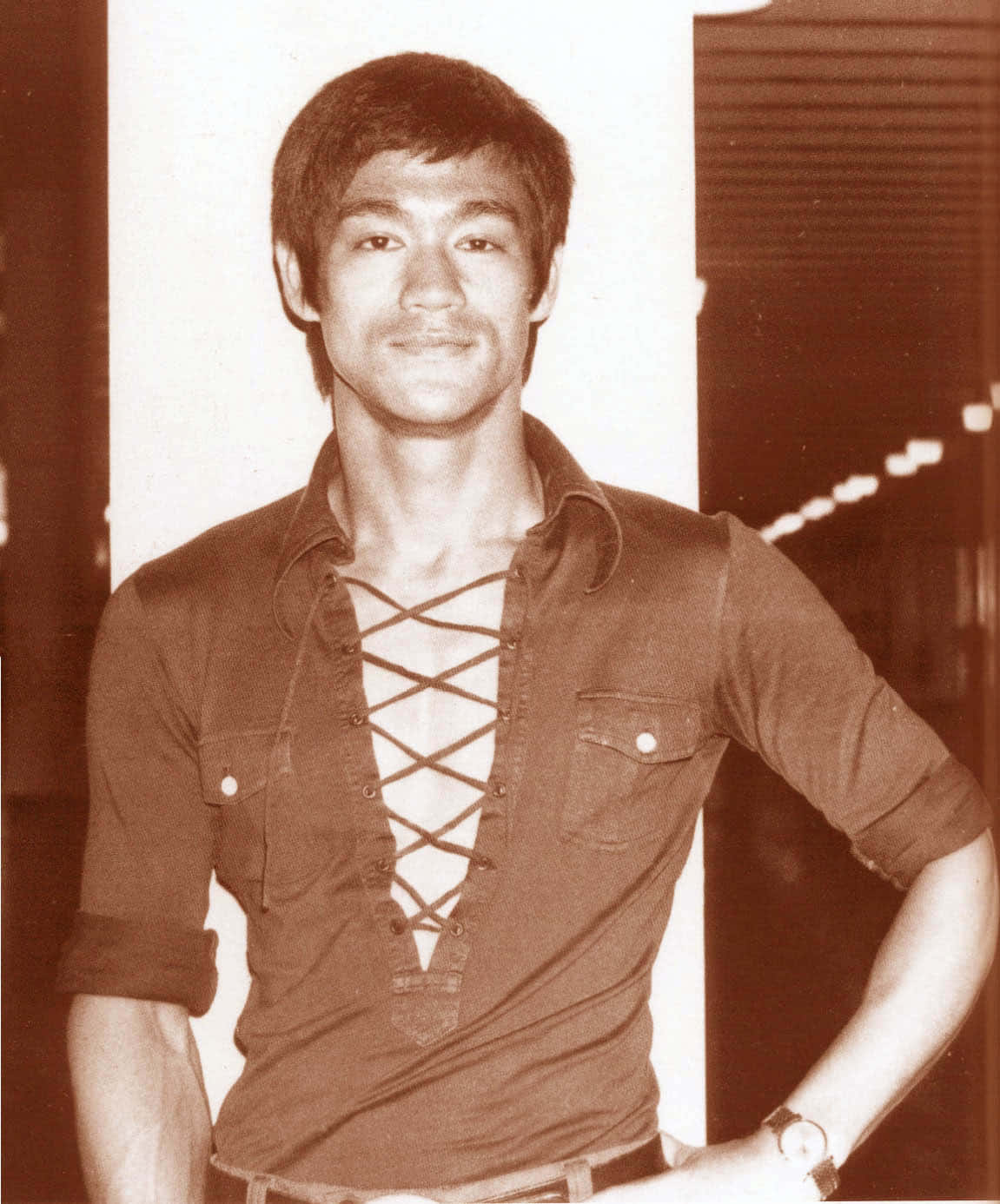 李小龍身穿繫帶襯衫，在復古工作室肖像中微笑。 — 李小龍 壁紙