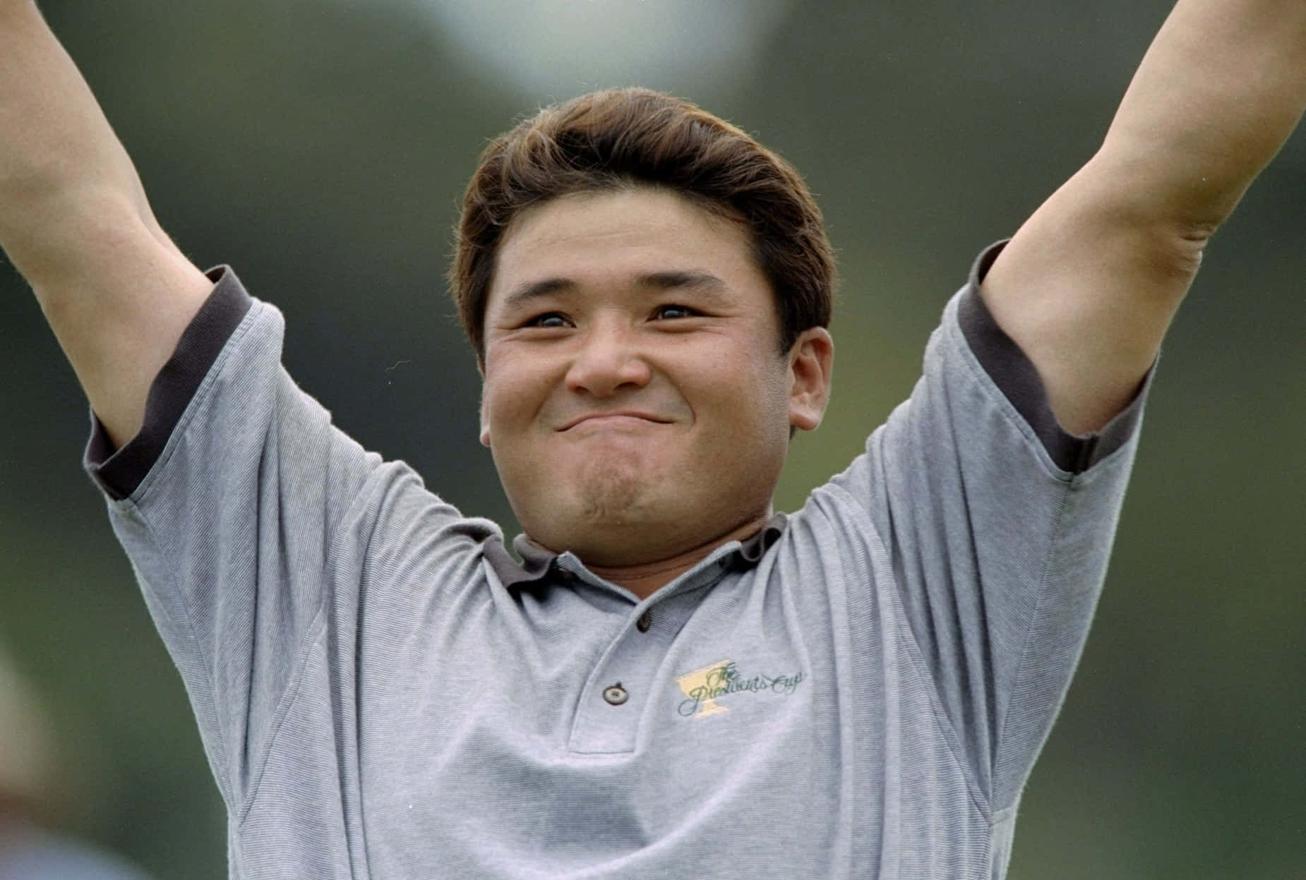 高爾夫球手高舉雙臂，露出燦爛笑容慶祝勝利。