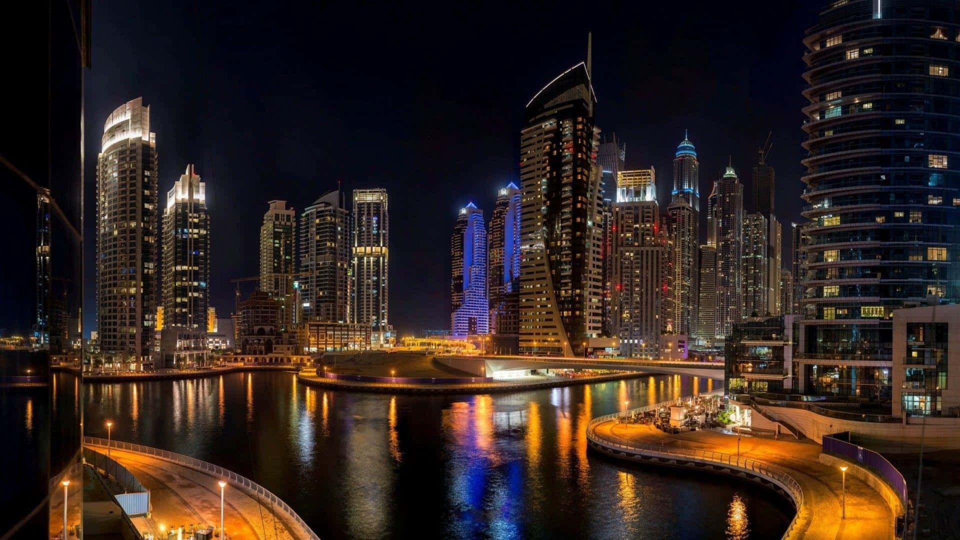 Uae 桌布 壁紙 — 杜拜令人目眩的夜景，在黑暗的天空下，燈火通明的摩天大樓倒映在平靜的水道上。