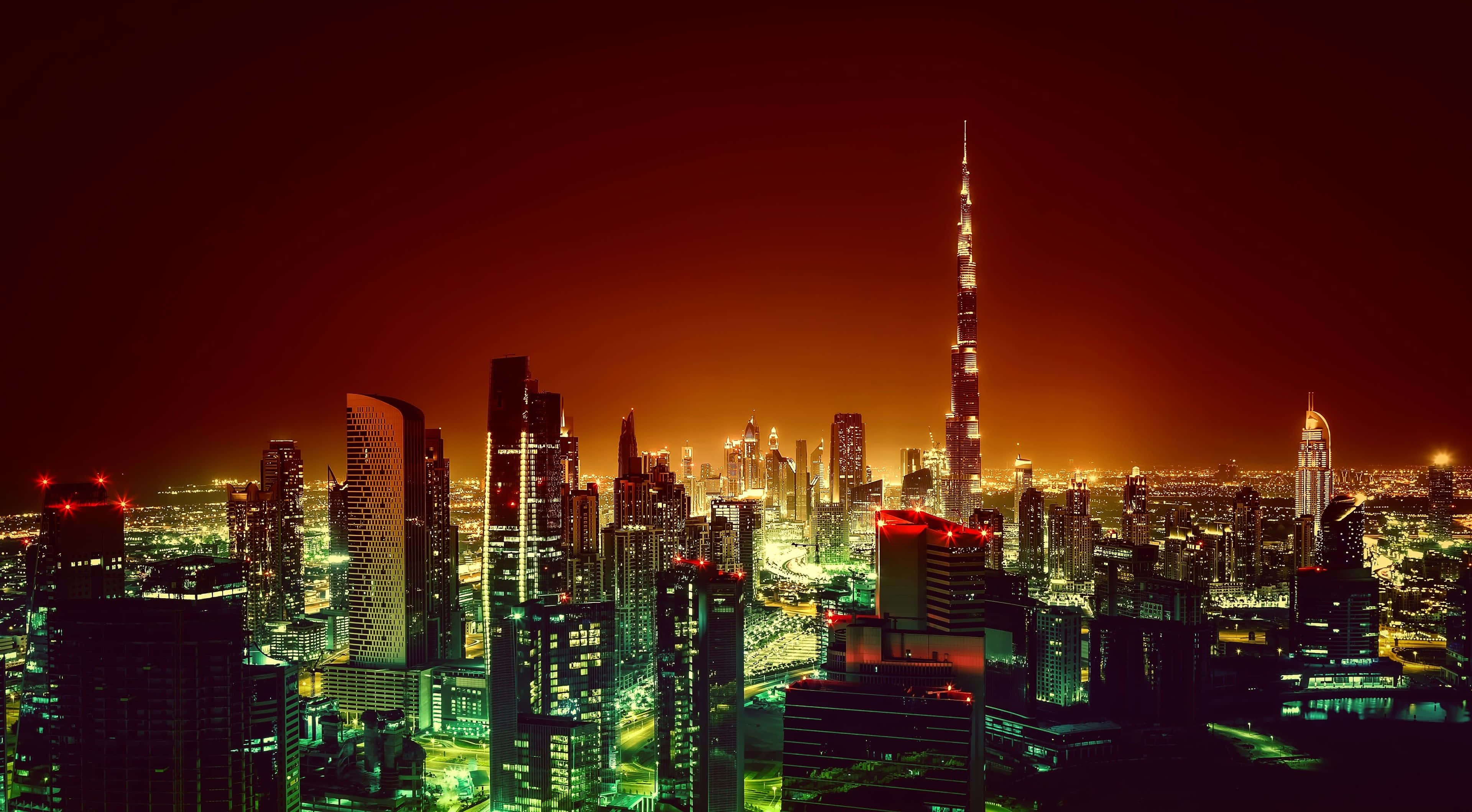 Dubai 桌布 壁紙 — 杜拜充滿活力的夜景，閃爍的摩天大樓和火紅色的天空。