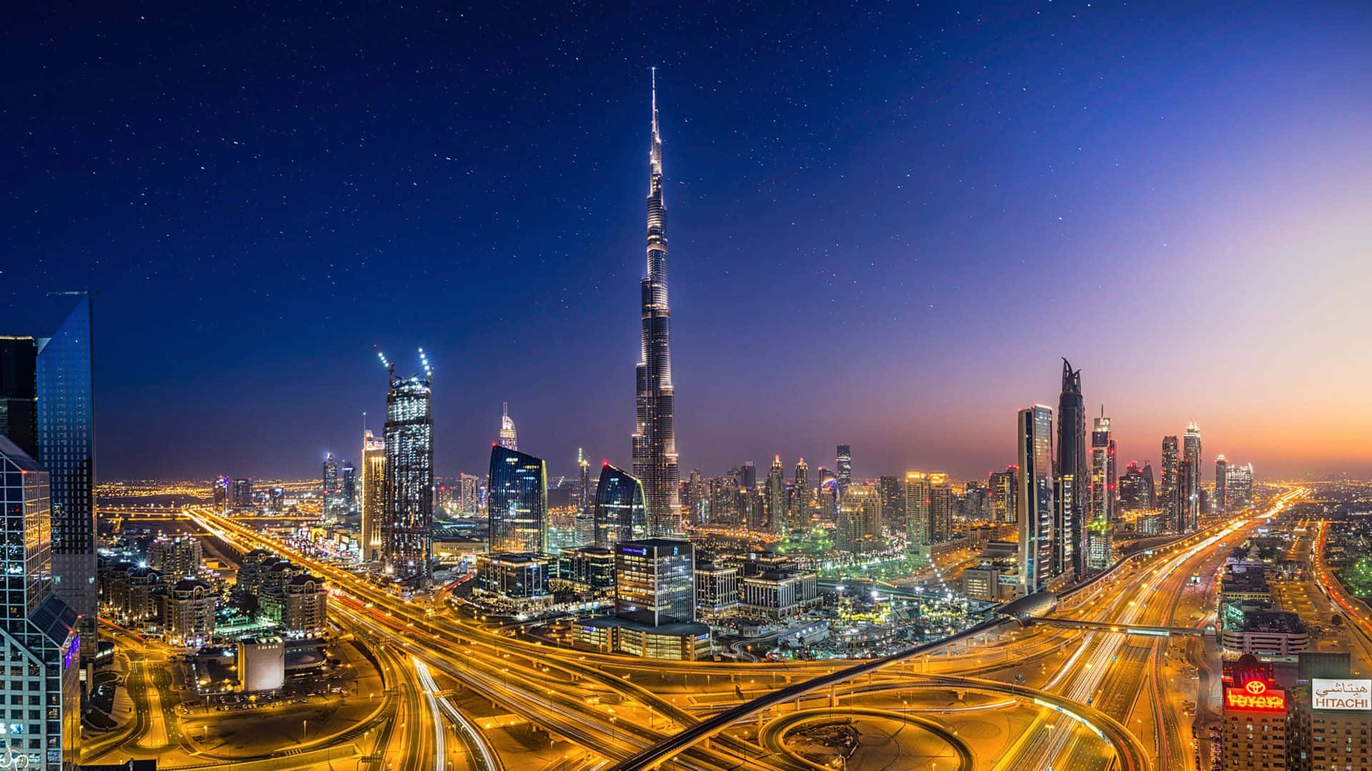 Dubai 桌布 壁紙 — 杜拜天際線的璀璨夜景，哈利法塔聳立在發光的高速公路和星空之上。
