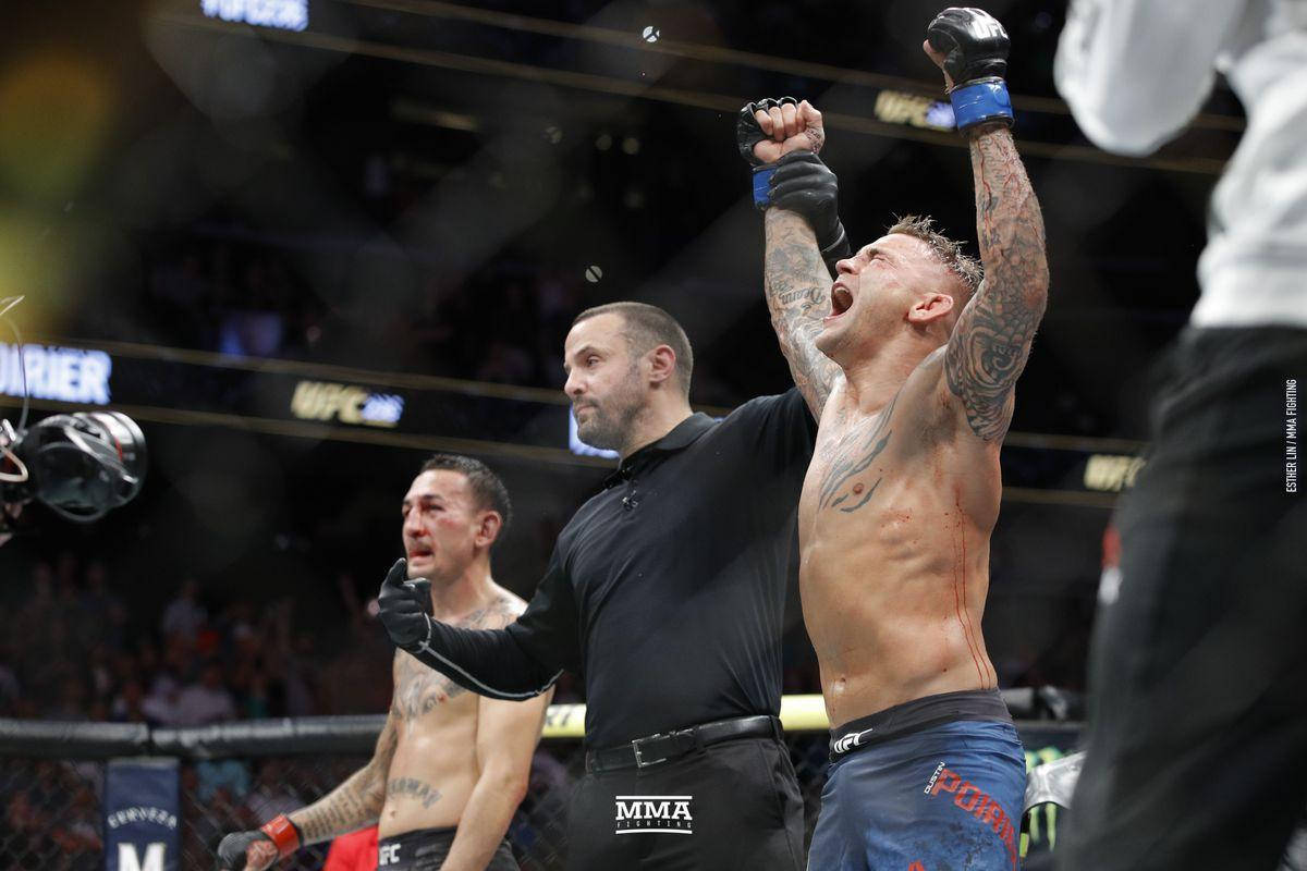 MMA拳手在八角籠中高舉雙臂慶祝勝利。