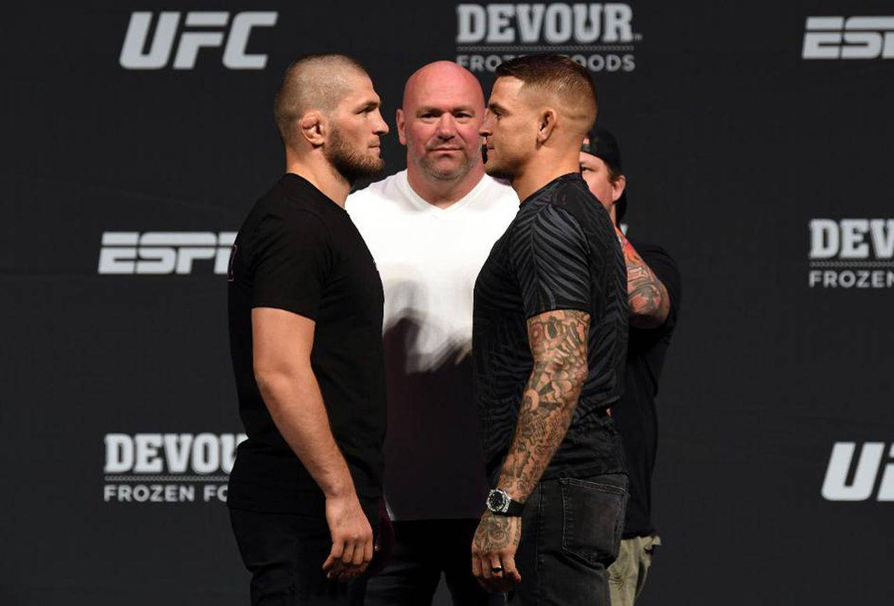 兩名男性MMA拳手在UFC稱重儀式上由裁判隔開，互相對峙。