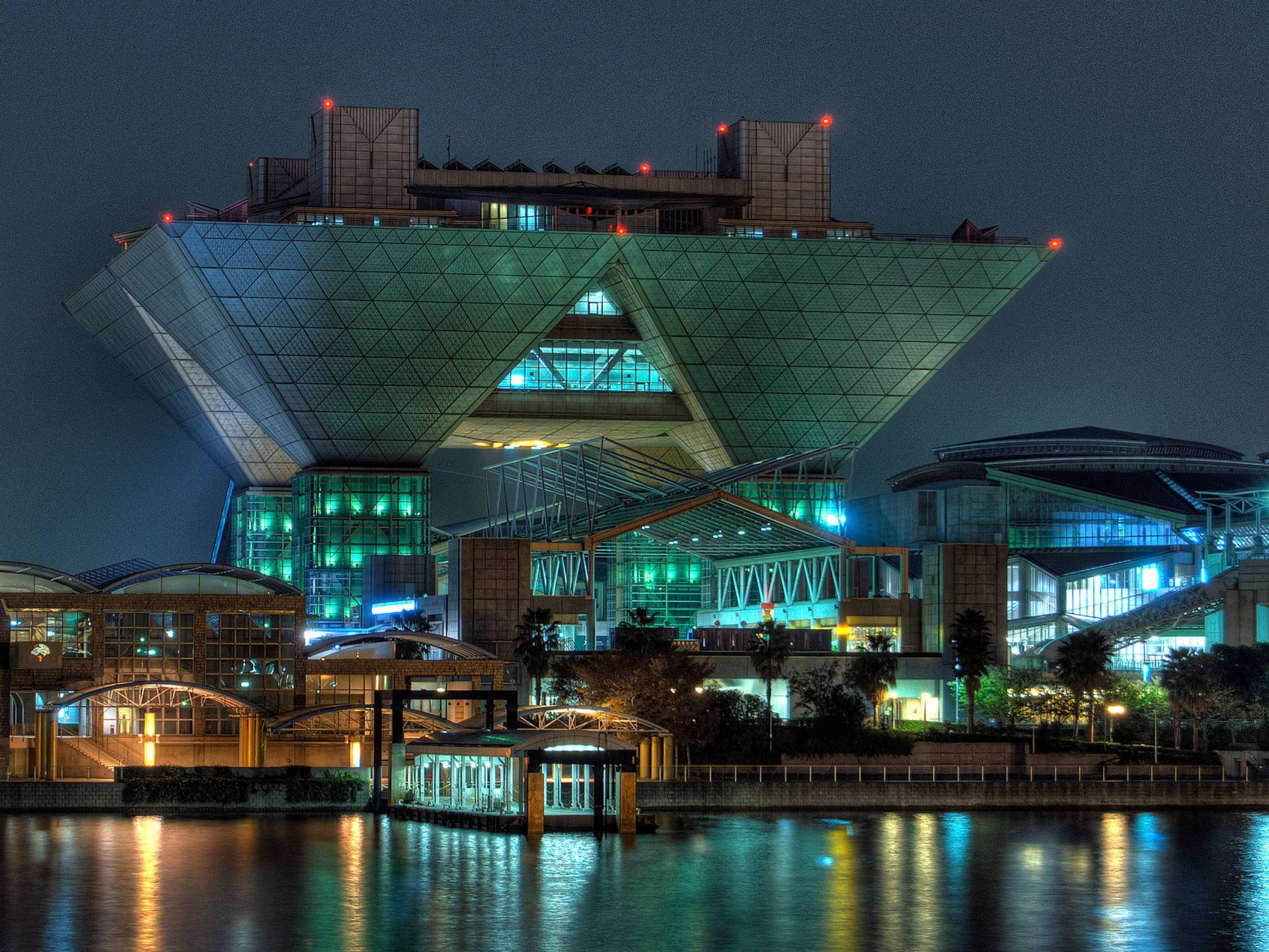 夜間發光的未來主義玻璃建築，水面倒影