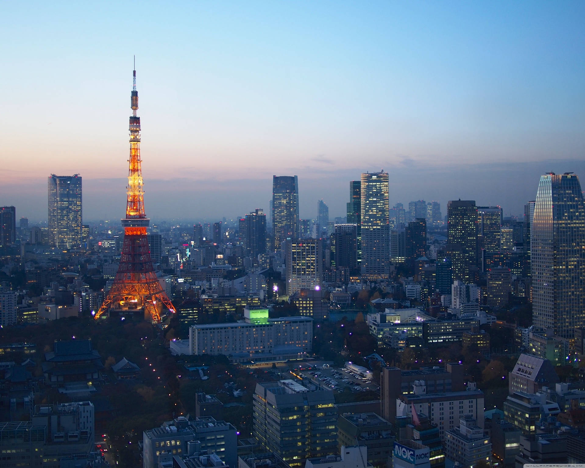 黃昏時分點亮的東京鐵塔，背景中城市燈光閃爍。