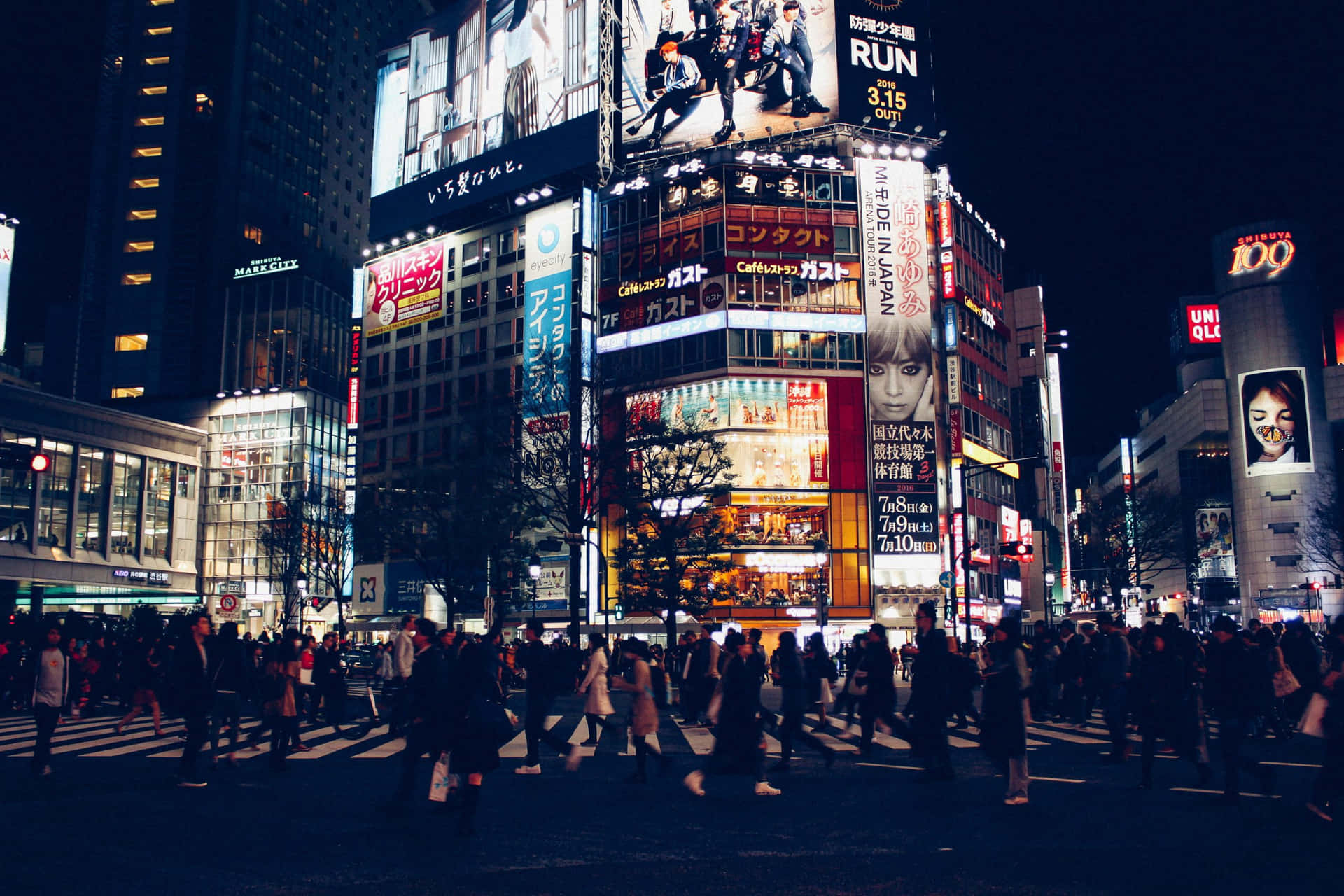 夜晚東京街道，霓虹燈招牌和人群穿過繁忙十字路口。